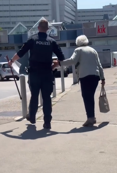 Hilfestellung für eine Seniorin im Straßenverkehr