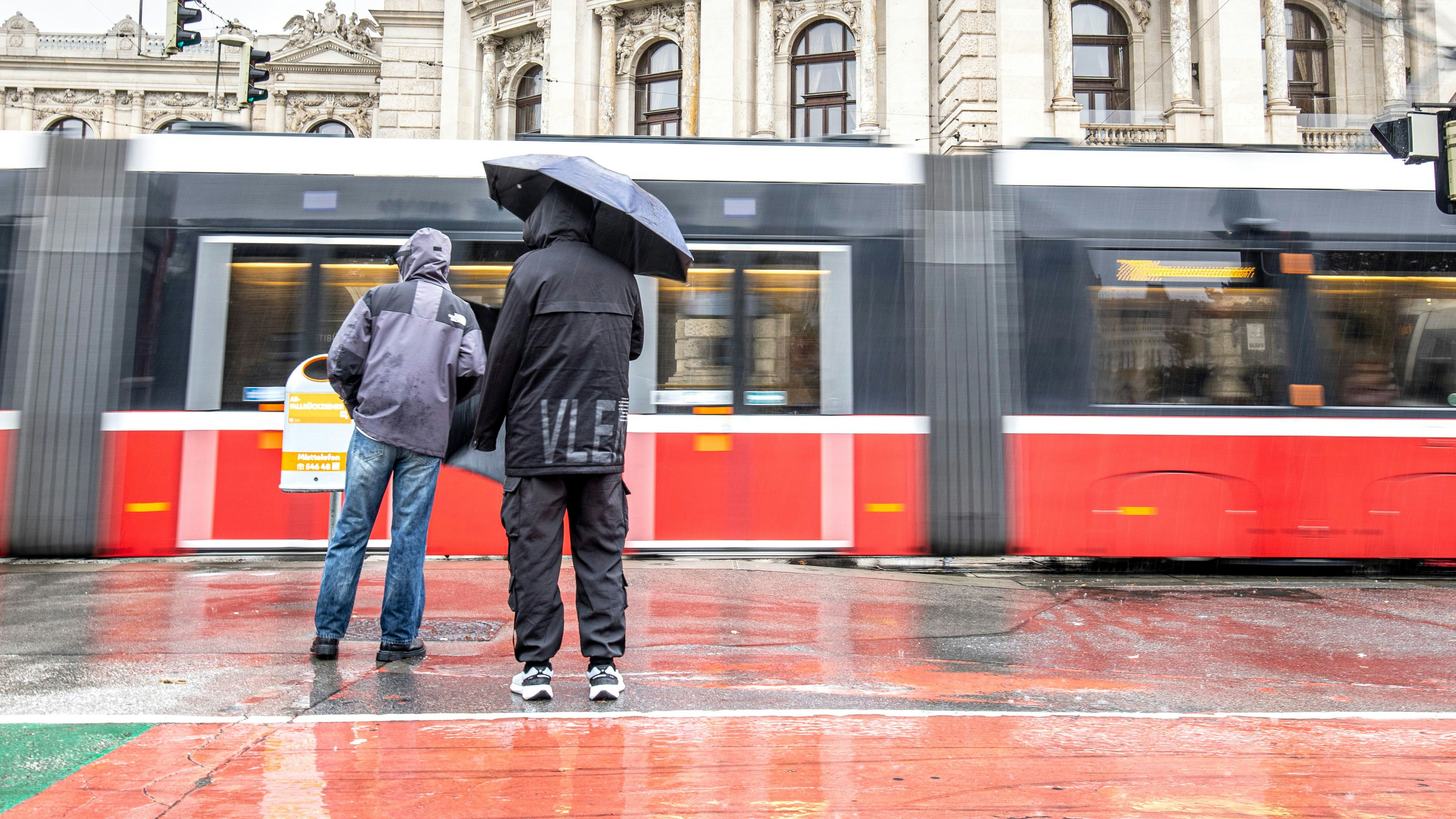 Passanten mit Regenschirmen spazieren in Wien. Archivbild