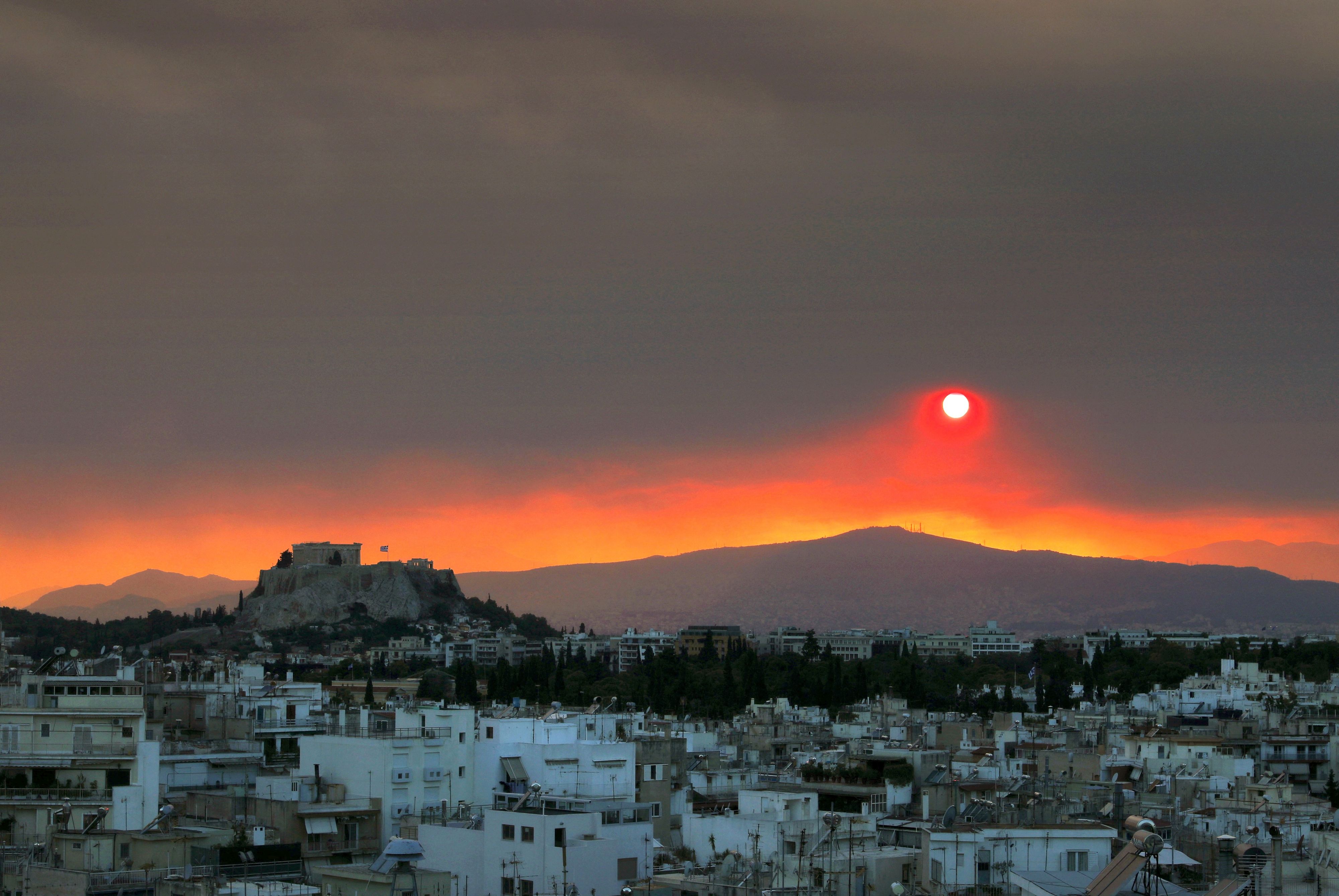 Sonnenuntergang über Athen: Im Hintergrund die Gluten eines heftigen Waldbrands.