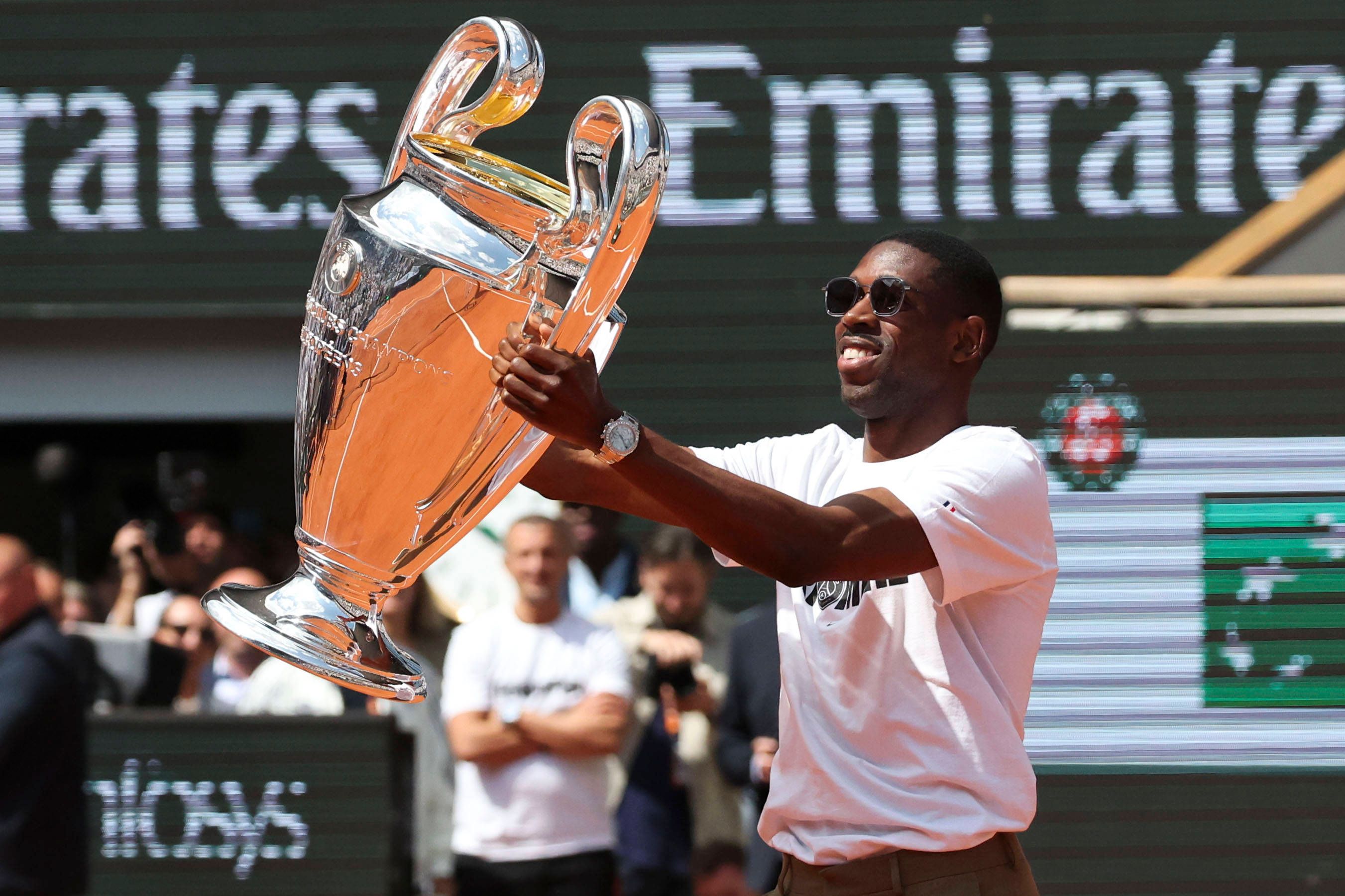 Ousmane Dembele zeigt dem French-Open-Publikum den Champions-League-Pokal.