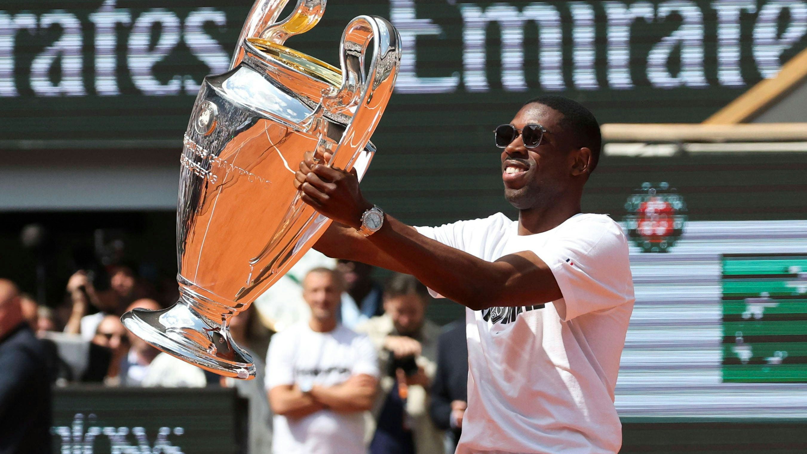 Ousmane Dembele zeigt dem French-Open-Publikum den Champions-League-Pokal.
