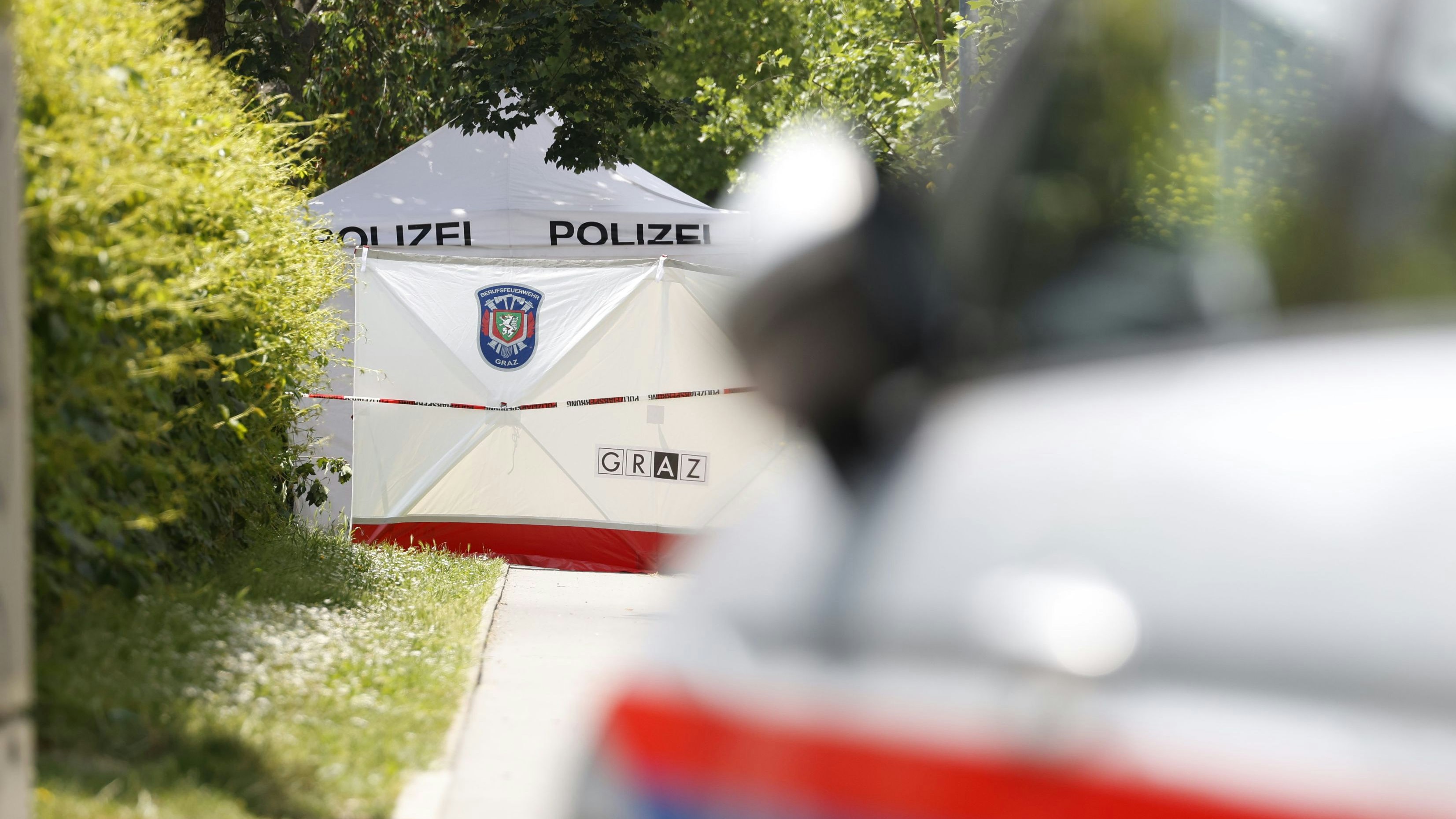  Bei der Attacke in der Grazer Schule in der Dreierschützengasse sind am Dienstagvormittag, 10. Juni 2025 10 Menschen gestorben. Im Bild: Ein Polizeiauto, ein Zelt und ein Sichtschutz in der Nähe des Tatorts in Graz. 