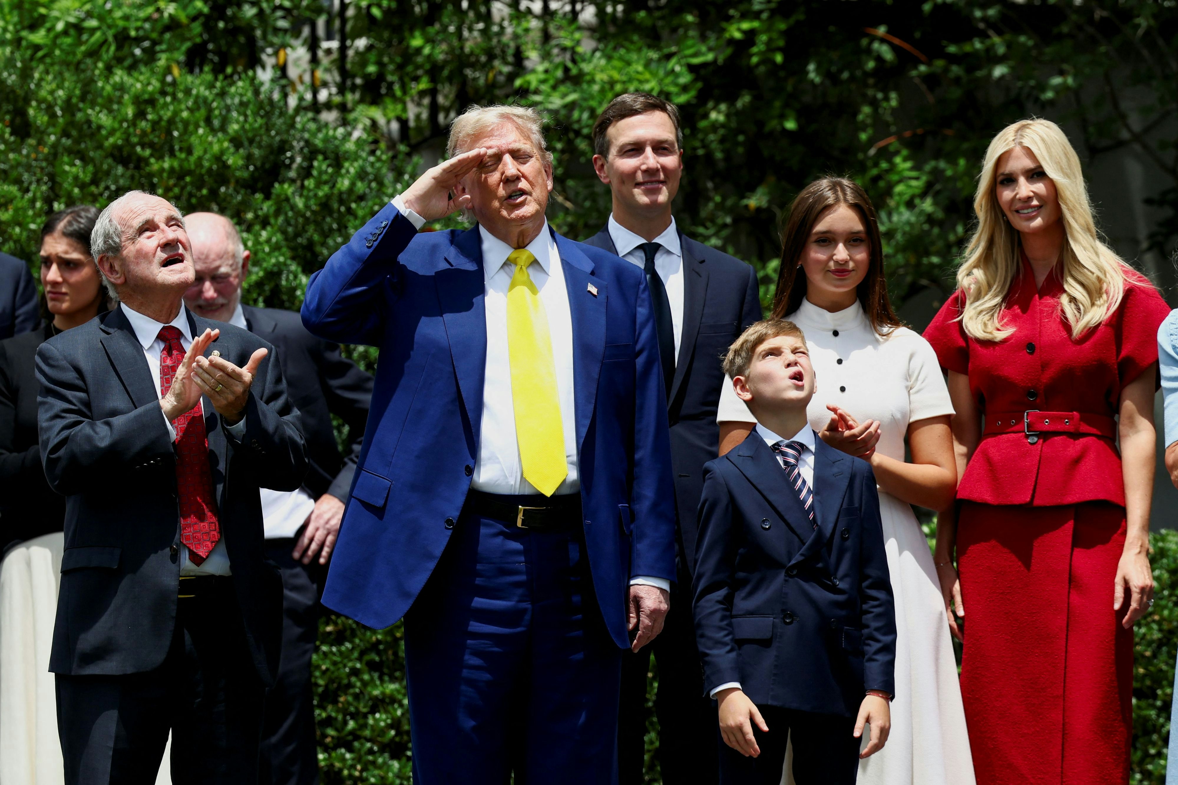US-Präsident Donald Trump salutiert neben Tochter Ivanka Trump und ihrem Ehemann Jared Kushner, während eine US-Flagge an einem neuen Fahnenmast auf dem South Lawn des Weißen Hauses in Washington D.C.gehisst wird
