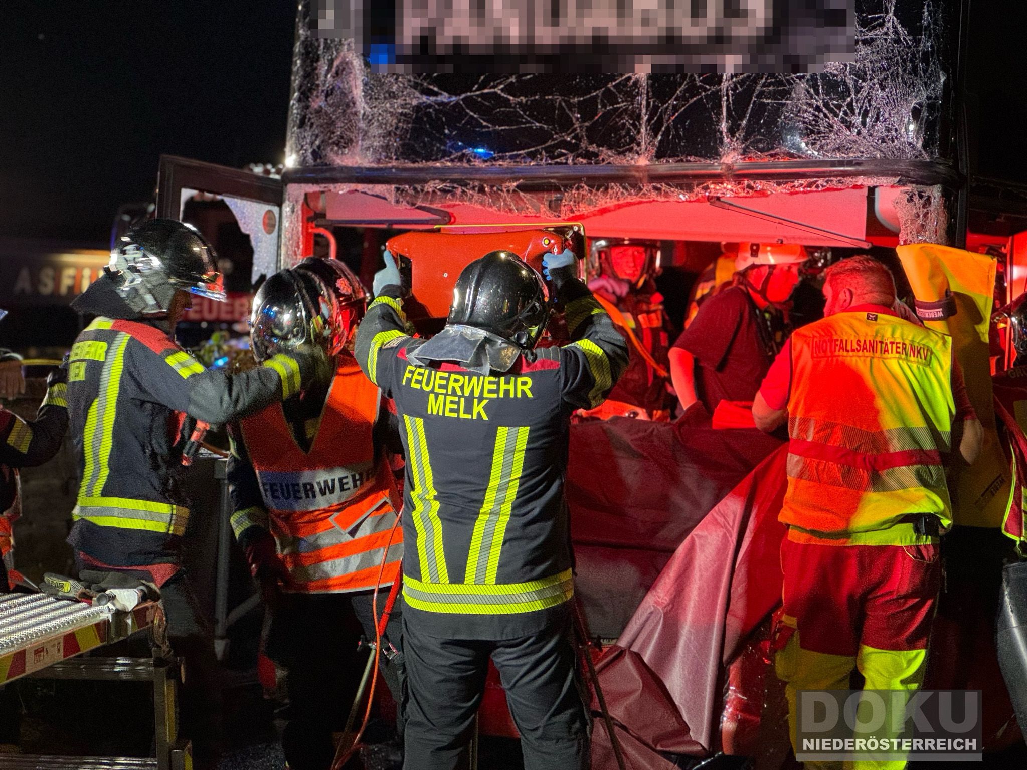 Kräfte der Feuerwehr vor der zerstörten Fahrerkabine des Reisebusses.