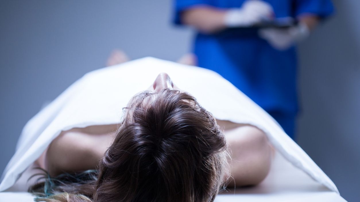 Closeup of remains of woman lying in morgue