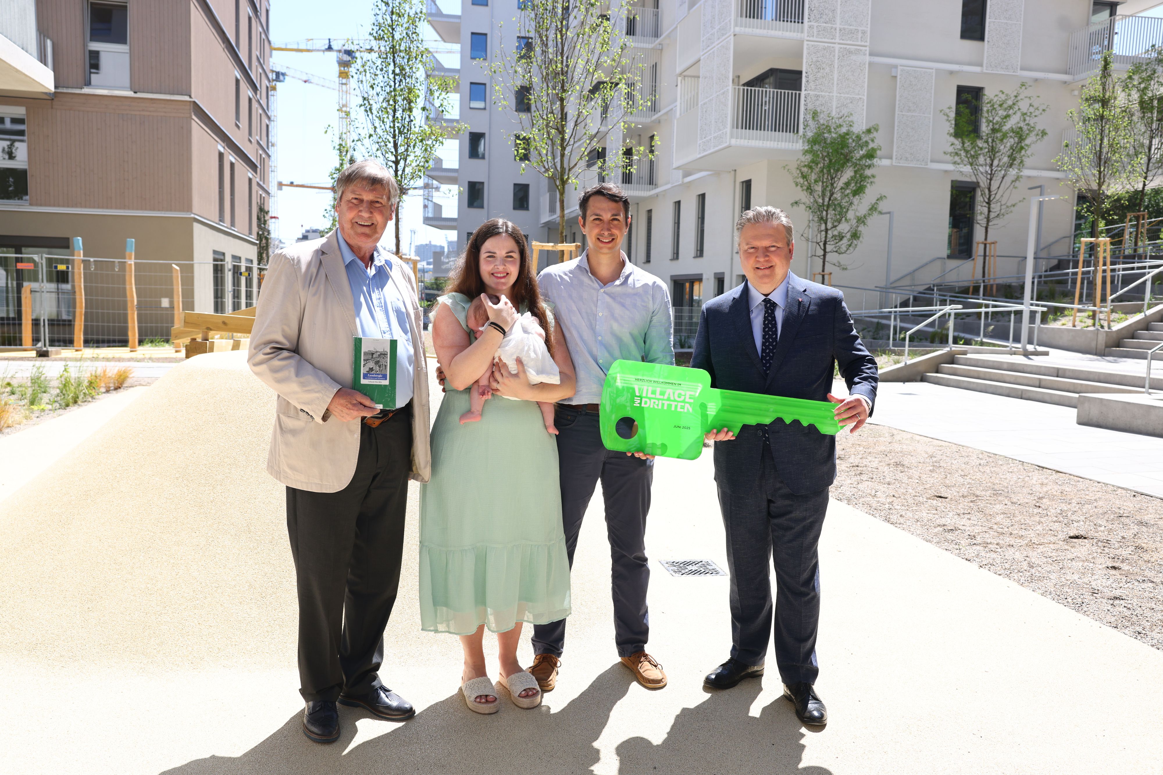 Bezirkschef Hohenberger, die frisch eingezogene Familie mit Baby und Bürgermeister Ludwig bei der symbolischen Schlüsselübergabe.