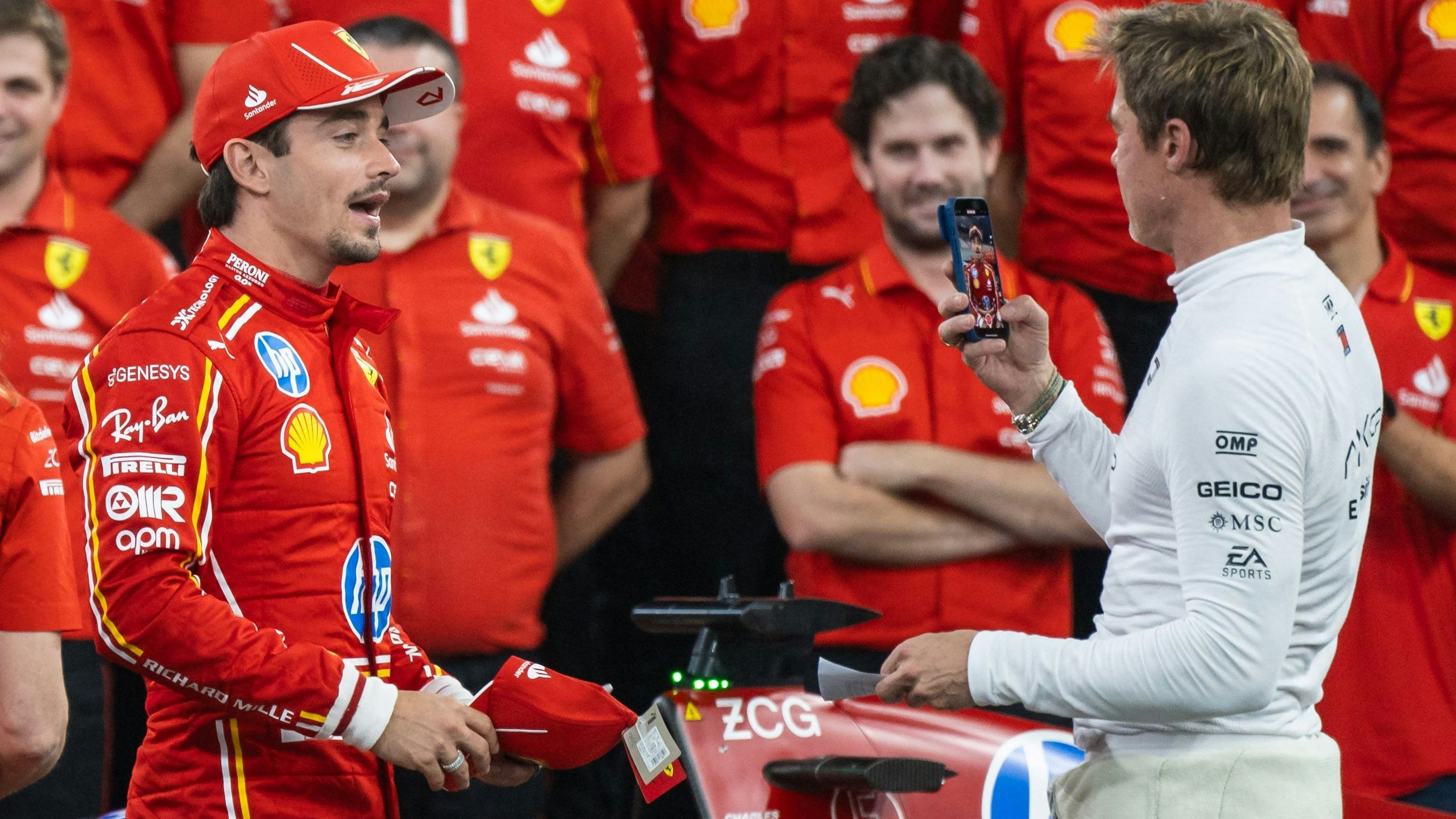 Wer ist hier der Fan von wem? Hollywoodstar Brad Pitt (r.) macht ein Foto von Ferrari-Star Charles Leclerc, dessen Team lacht sich darüber eins