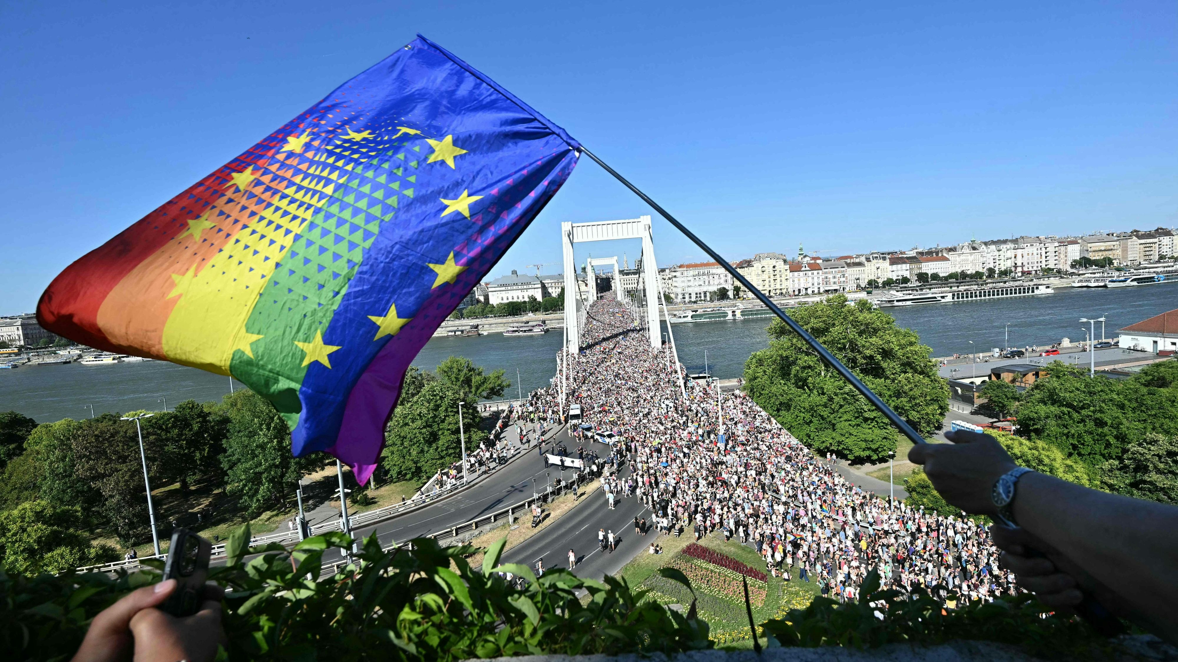 Download von www.picturedesk.com am 28.06.2025 (21:13).  People wave a rainbow EU flag as they take part in the Budapest Pride parade in Budapest downtown on June 28, 2025, as the capital's municipality organised this march by the LGBTQ community, celebrating freedom, in a move to circumvent a law that allows police to ban LGBTQ marches. Hungary's Prime Minister had announced that police will not "break up" Saturday's Budapest Pride march despite issuing a ban, but warned attendees and organisers about the legal consequences. His ruling coalition amended laws and the constitution earlier this year to prohibit the annual celebration, advancing his widely condemned, years-long clampdown on LGBTQ rights in the name of "child protection". (Photo by Attila KISBENEDEK / AFP) - 20250628_PD6485 - Rechteinfo: Rights Managed (RM) Nur für redaktionelle Nutzung! Werbliche Nutzung erfordert Freigabe: bitte schicken Sie uns eine Anfrage.