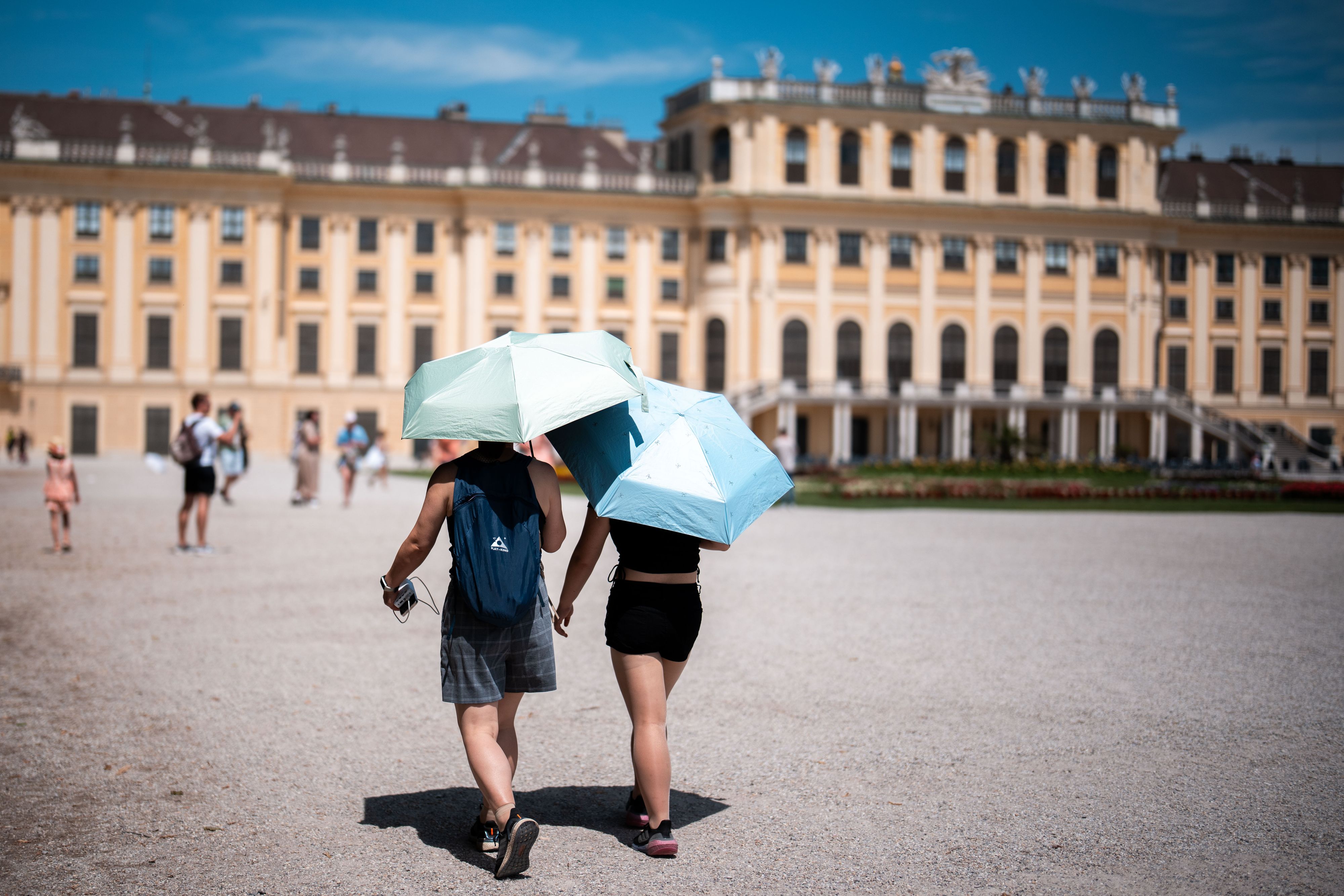 Es ist heiß in Österreich: Touristen mit Sonnenschirm am 30. Juni 2025 im Schlosspark Schönbrunn.