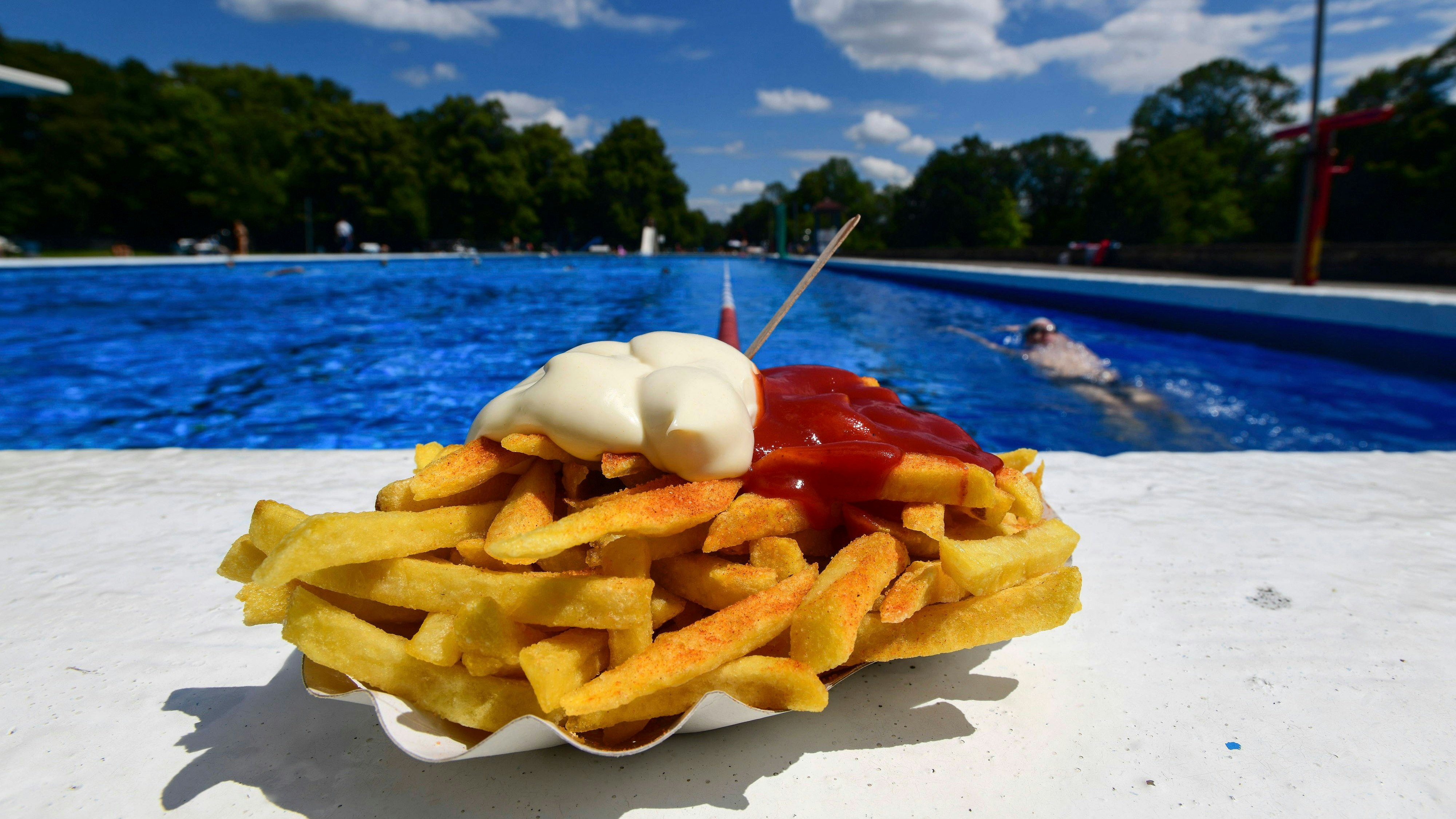 Pommes Frites sind frittierte Stäbchen aus Kartoffeln. Ursprünglich in Belgien verbreitet, gibt es sie heute weltweit als Beilage und Imbiss. Im Bild eine Portion Pommes mit Ketchup und Mayonnaise als Snack in einer Einweg-Pappschale mit Pieker an einem Badetag im Annabad. Symbolfoto, Themenfoto Hanover, 06.09.2024 *** French fries are deep-fried sticks made from potatoes Originally common in Belgium, they are now available worldwide as a side dish and snack The picture shows a portion of French fries with ketchup and mayonnaise as a snack in a disposable paper bowl with a pecker on a bathing day at Annabad Symbol photo, theme photo Hanover, 06 09 2024 Foto:xN.xHeuselx/xFuturexImagex pommes_4903