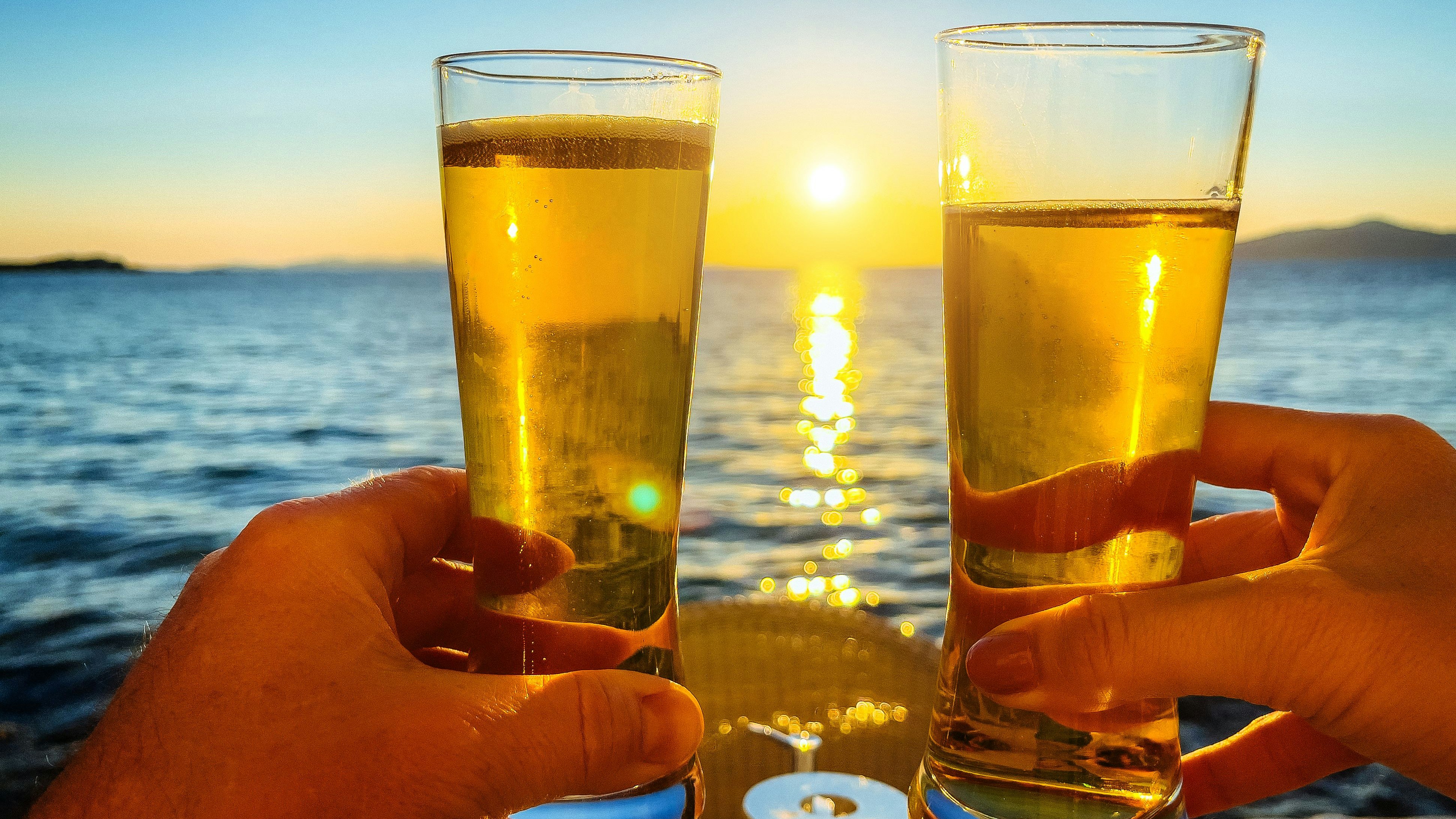 Toasting with bear at sunset, Little Venice Mykonos town (Chora), Mykonos island, Cyclades, Greece.