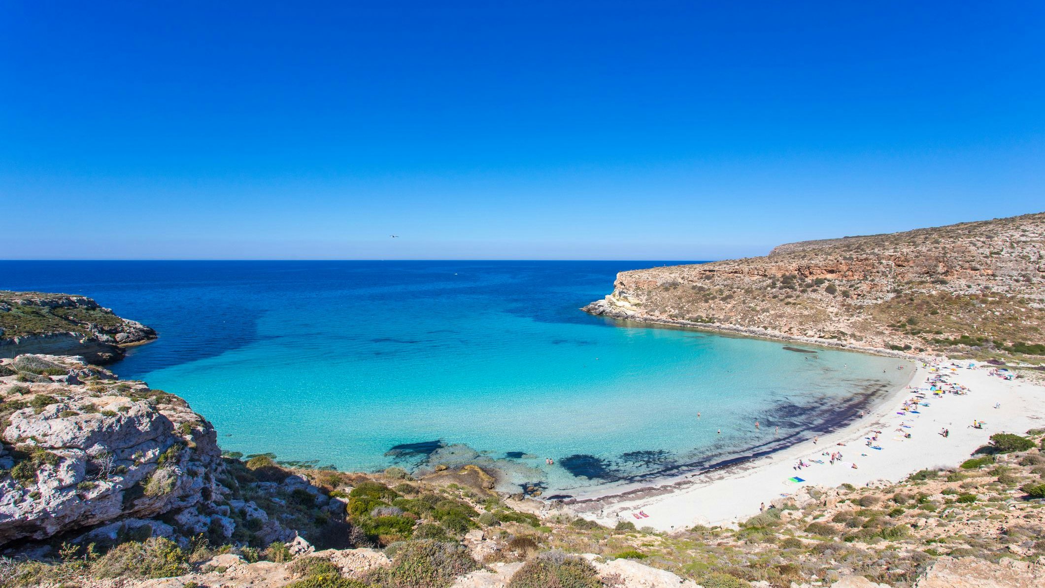 Lampedusa Island Sicily - Rabbit Beach and Rabbit Island Lampedusa “Spiaggia dei Conigli” with turquoise water and white sand at paradise beach. Mediterranean scrub with thyme and cardoon. Tabaccara Bay