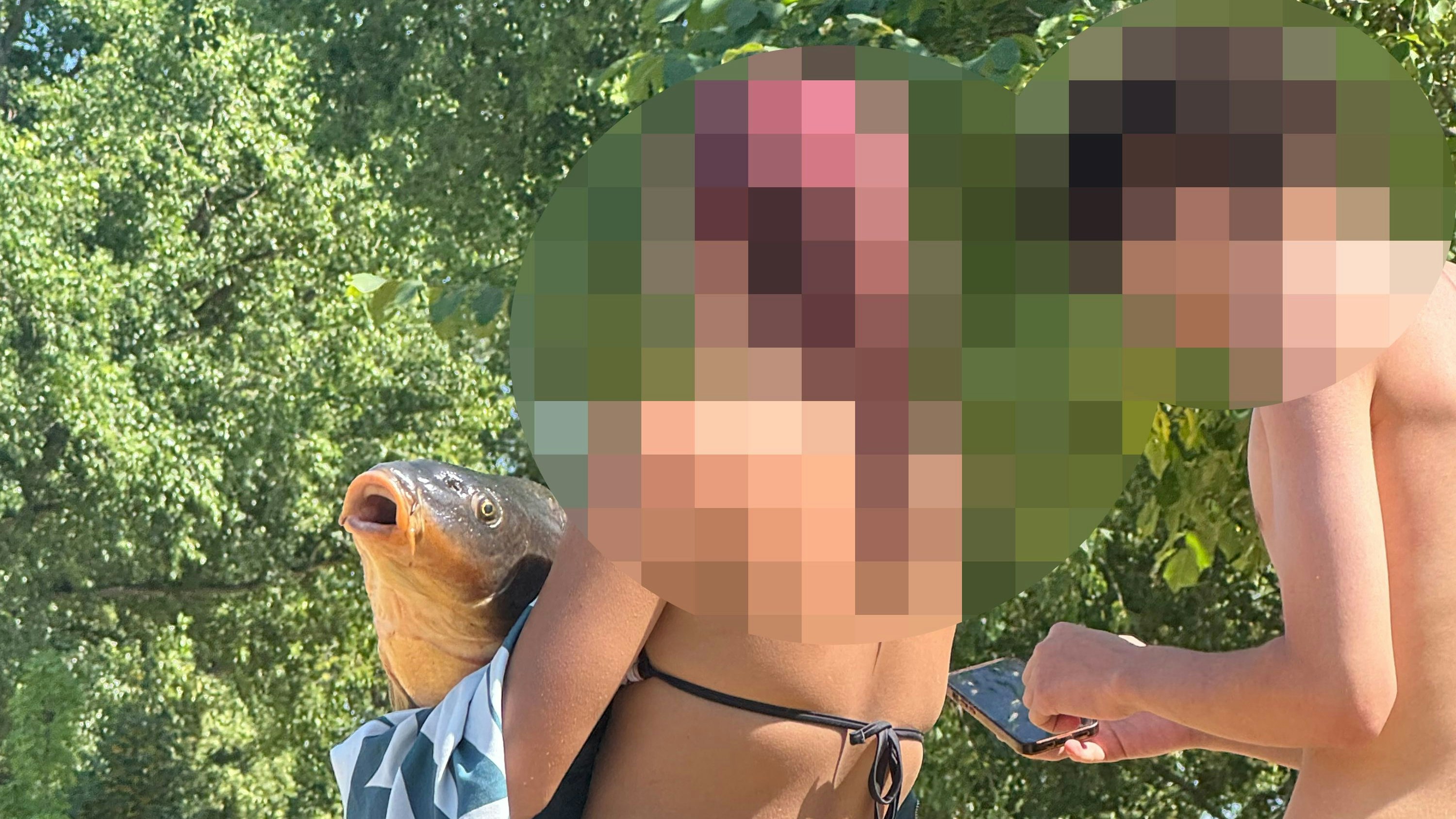 Pärchen posiert mit Karpfen im Strandbad Alte Donau. Wenig später trieb der Fisch leblos im Wasser.