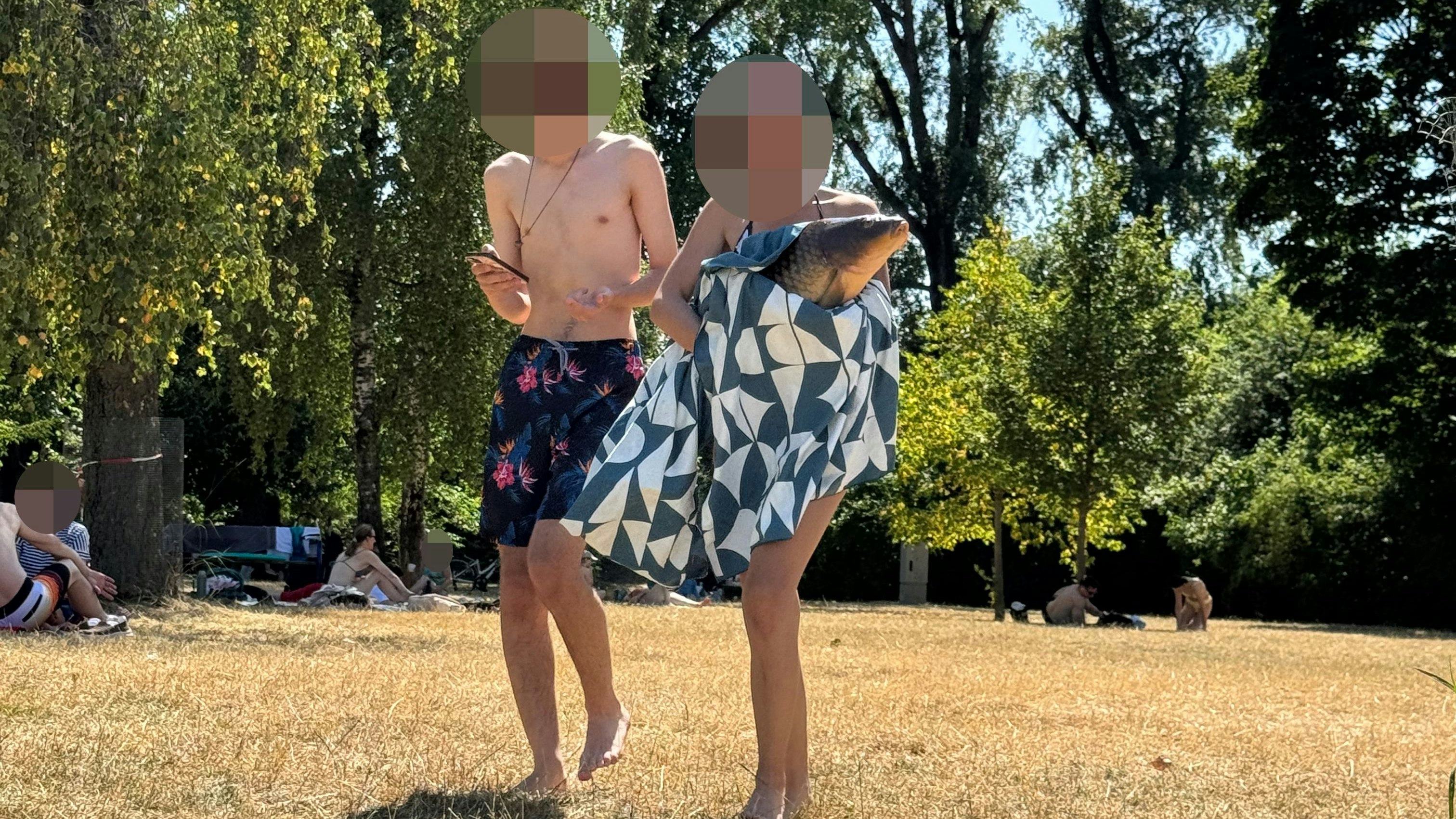 Mitten im Strandbad spaziert das Paar mit dem lebenden Karpfen – um später Fotos zu machen.
