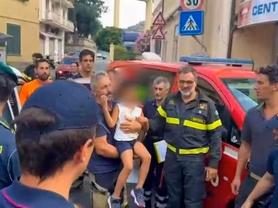 In den Armen der Rettungskräfte wurde der wiedergefundene Fünfjährige mit Applaus von einer kleinen Menschenmenge in Ventimiglia empfangen.