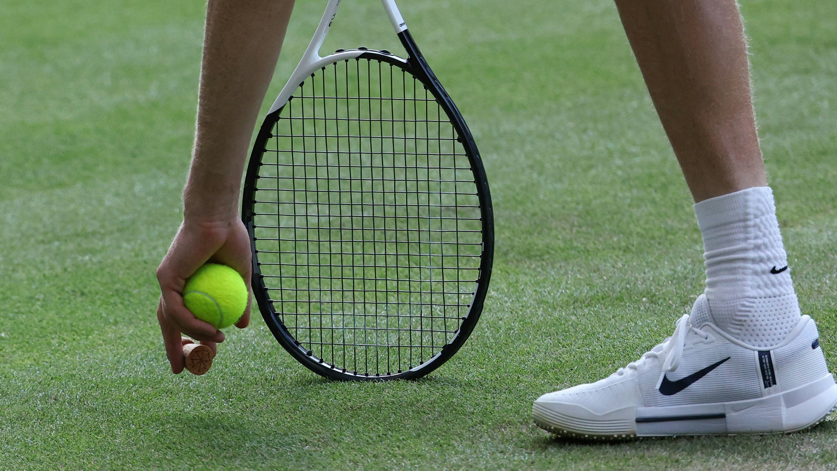 Tennis - Wimbledon - All England Lawn Tennis and Croquet Club, London, Britain - July 13, 2025 Italy's Jannik Sinner picks up a champagne cork which landed on court during the men's singles final against Spain's Carlos Alcaraz REUTERS/Toby Melville