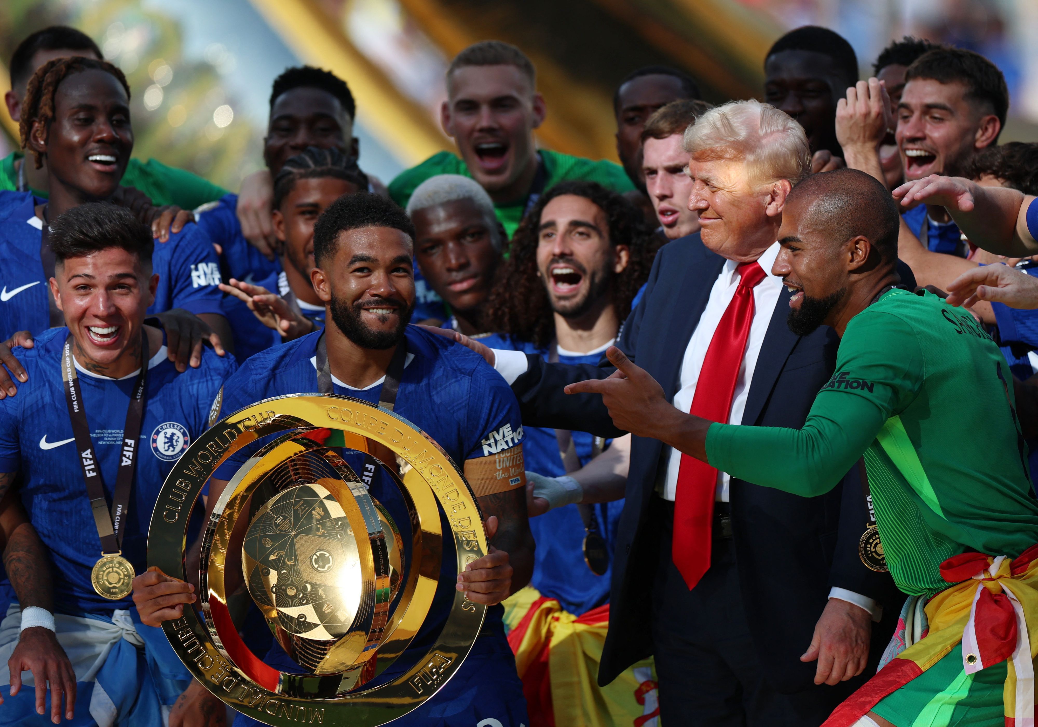 Trump grinsend am Siegerpodest mit den Chelsea-Stars