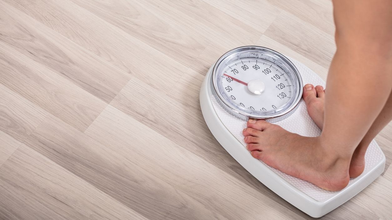 Low Section Of Woman Foot On Weighting Scale At Home