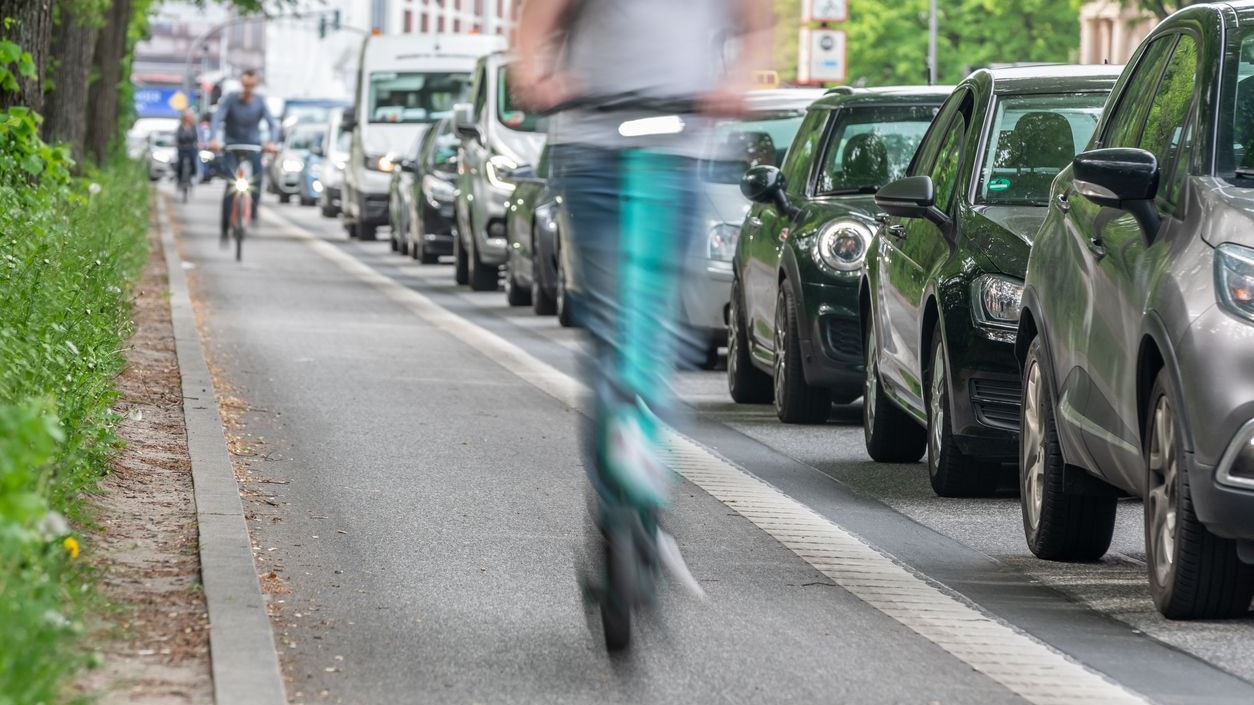 an e-scooter on the bike path overtakes cars in a traffic jam