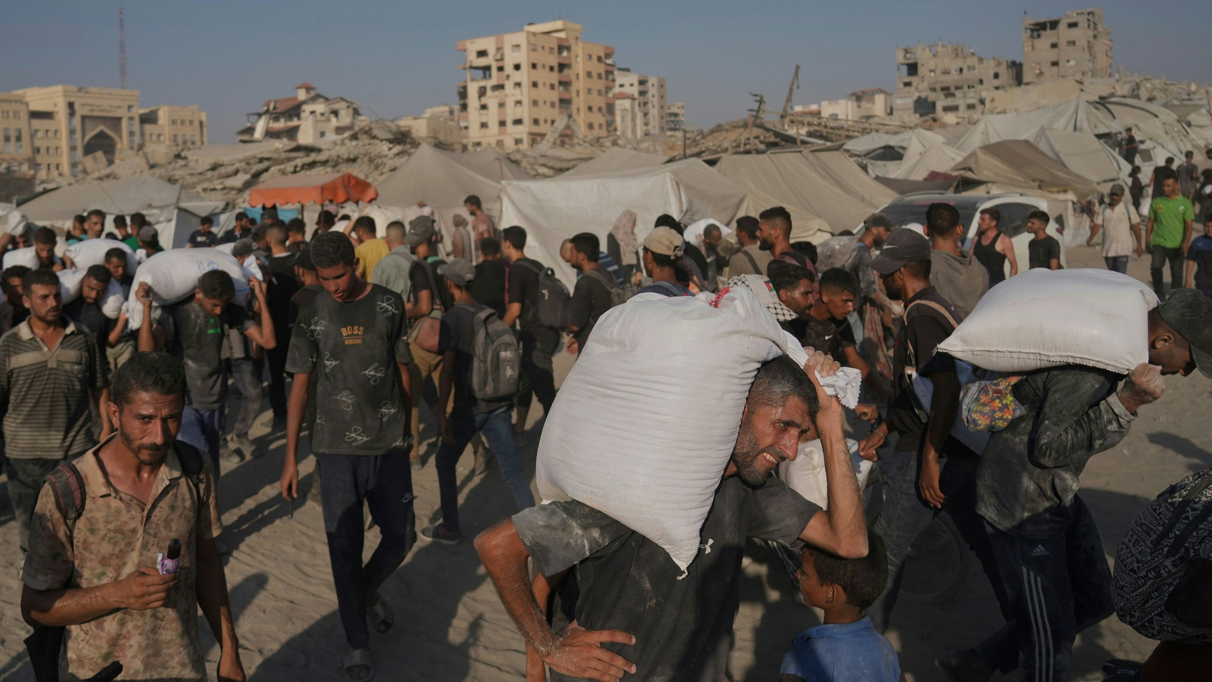 Download von www.picturedesk.com am 27.07.2025 (08:34).  Palestinians carry sacks of flour unloaded from a humanitarian aid convoy that reached Gaza City from the northern Gaza Strip, Saturday, July 26, 2025. (AP Photo/Jehad Alshrafi) - 20250726_PD8438 - Rechteinfo: Rights Managed (RM)