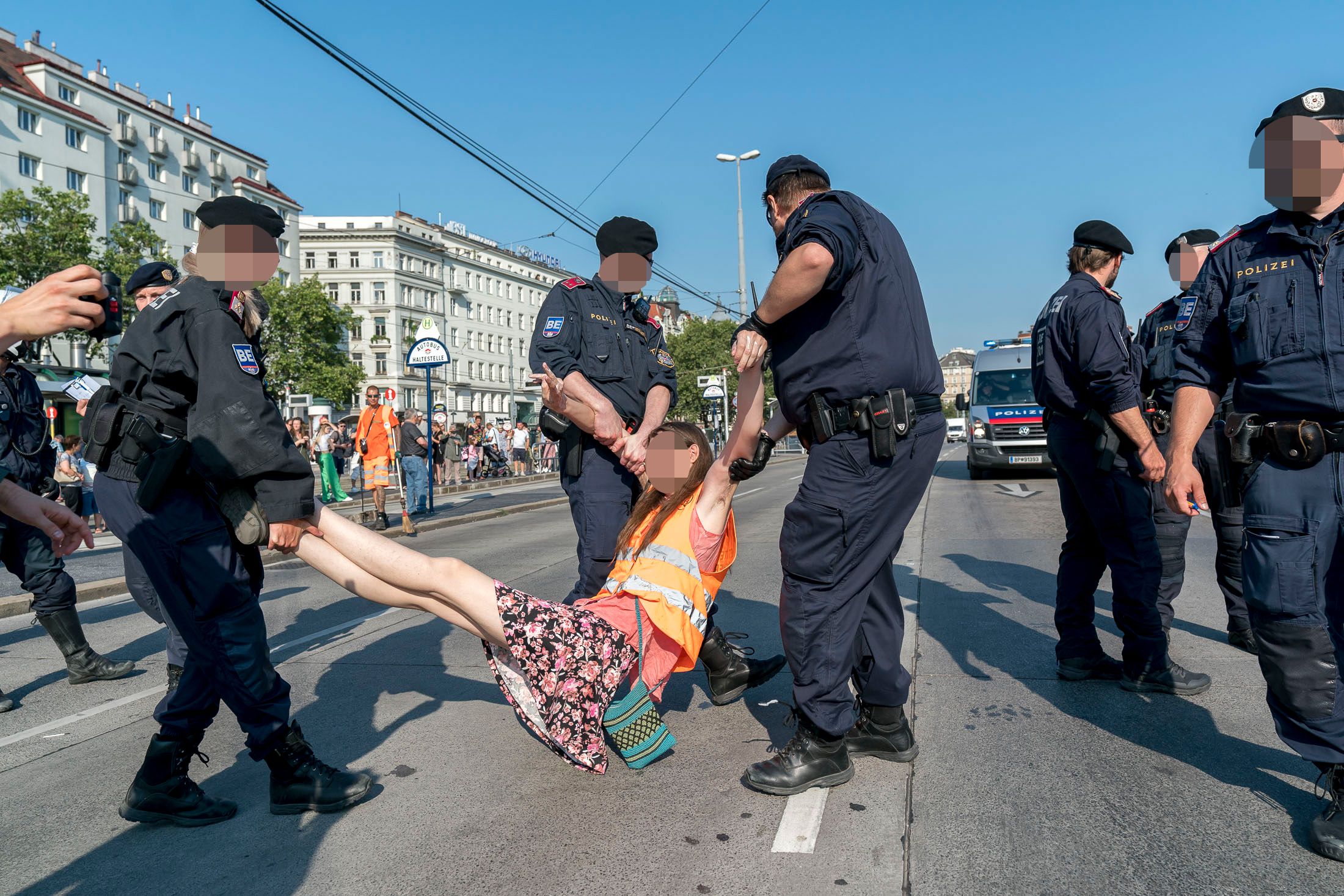Polizisten tragen eine Klimaaktivistin der 