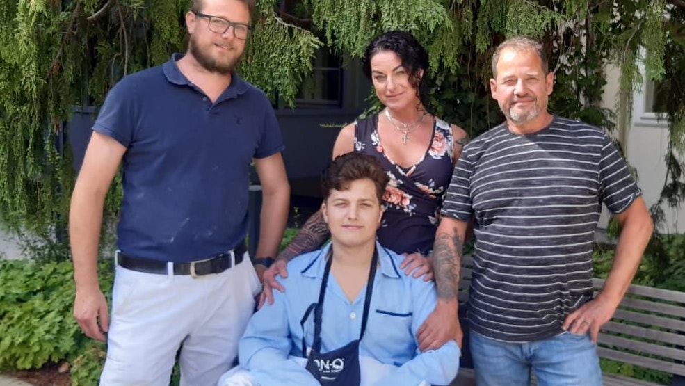 Prothesen-Meister Martin Spenker, Mama Petra und Papa Harald Unfried mit Maxi im Rollstuhl.