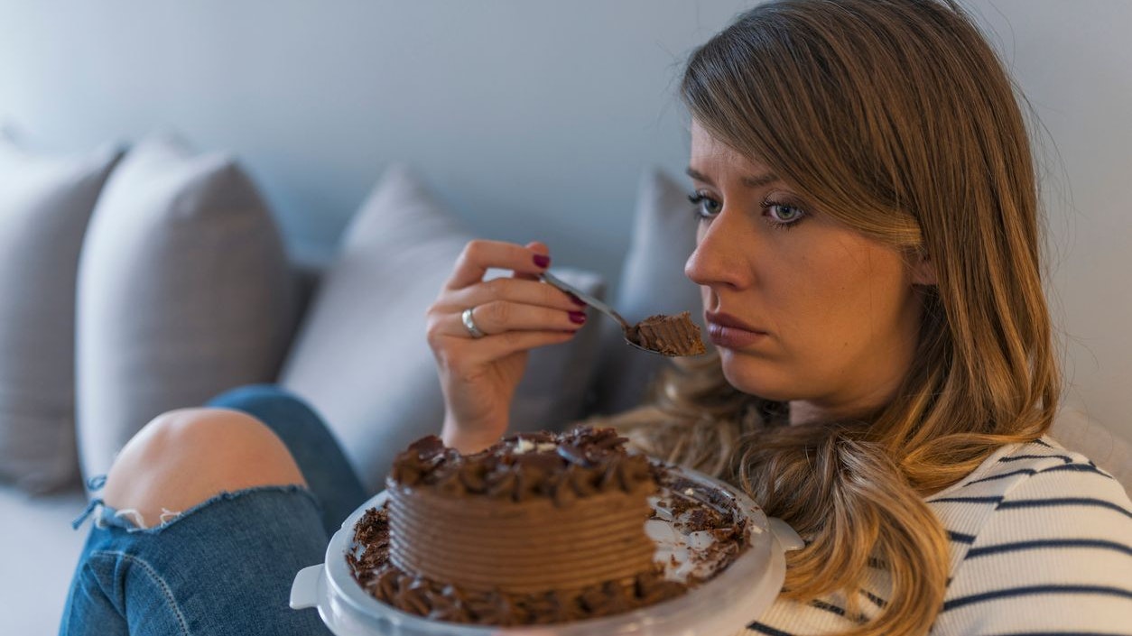 Depressed woman eats cake.  Sad unhappy woman eating cake. Sad woman eating sweet cake. Close up of woman eating chocolate cake. food, junk-food, culinary, baking and holidays concept