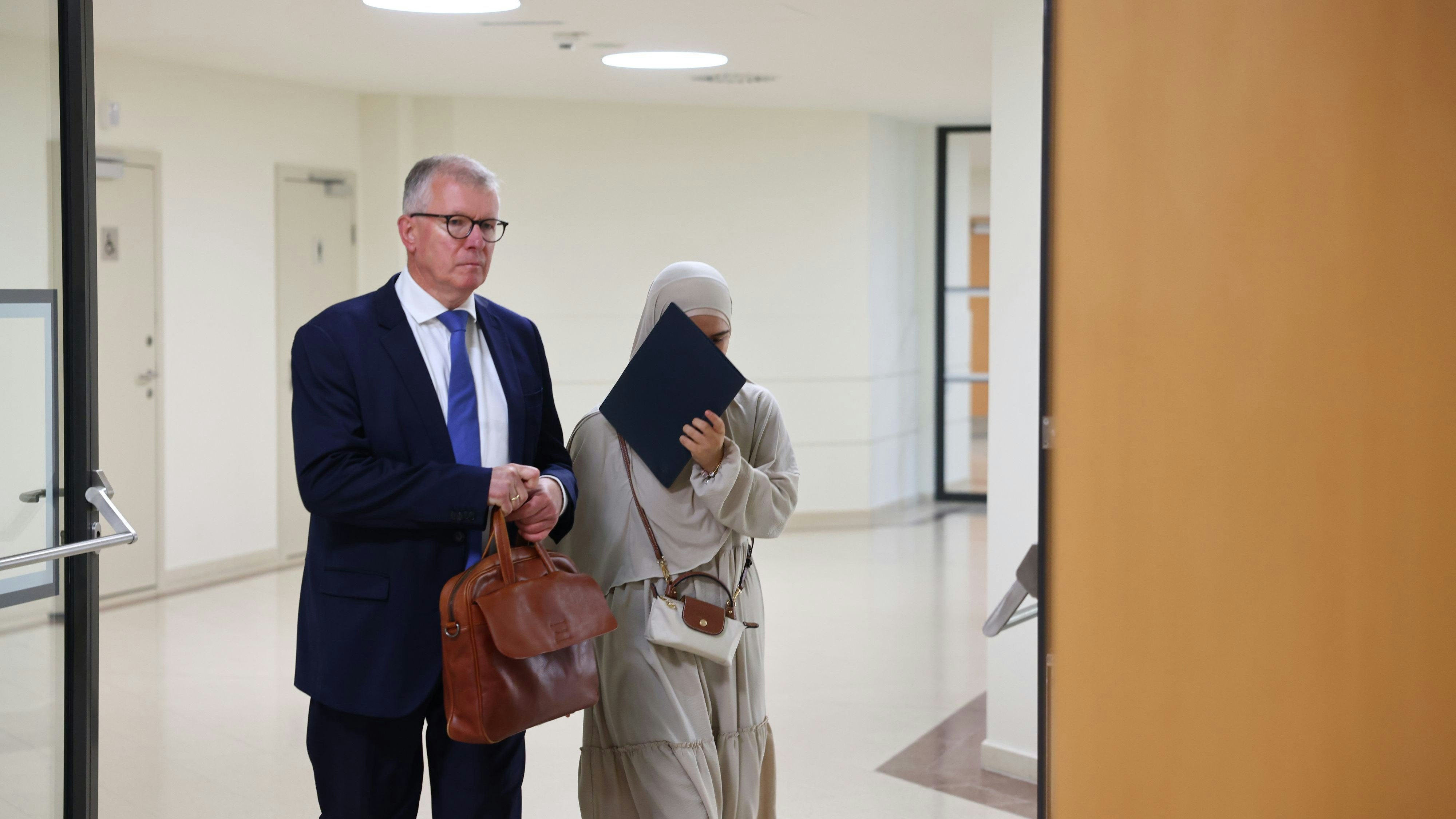 Mit Aktenmappe vor dem Gesicht: Die 19-jährige Angeklagte erscheint mit ihrem Anwalt zur Urteilsverkündung am Wiener Landesgericht.