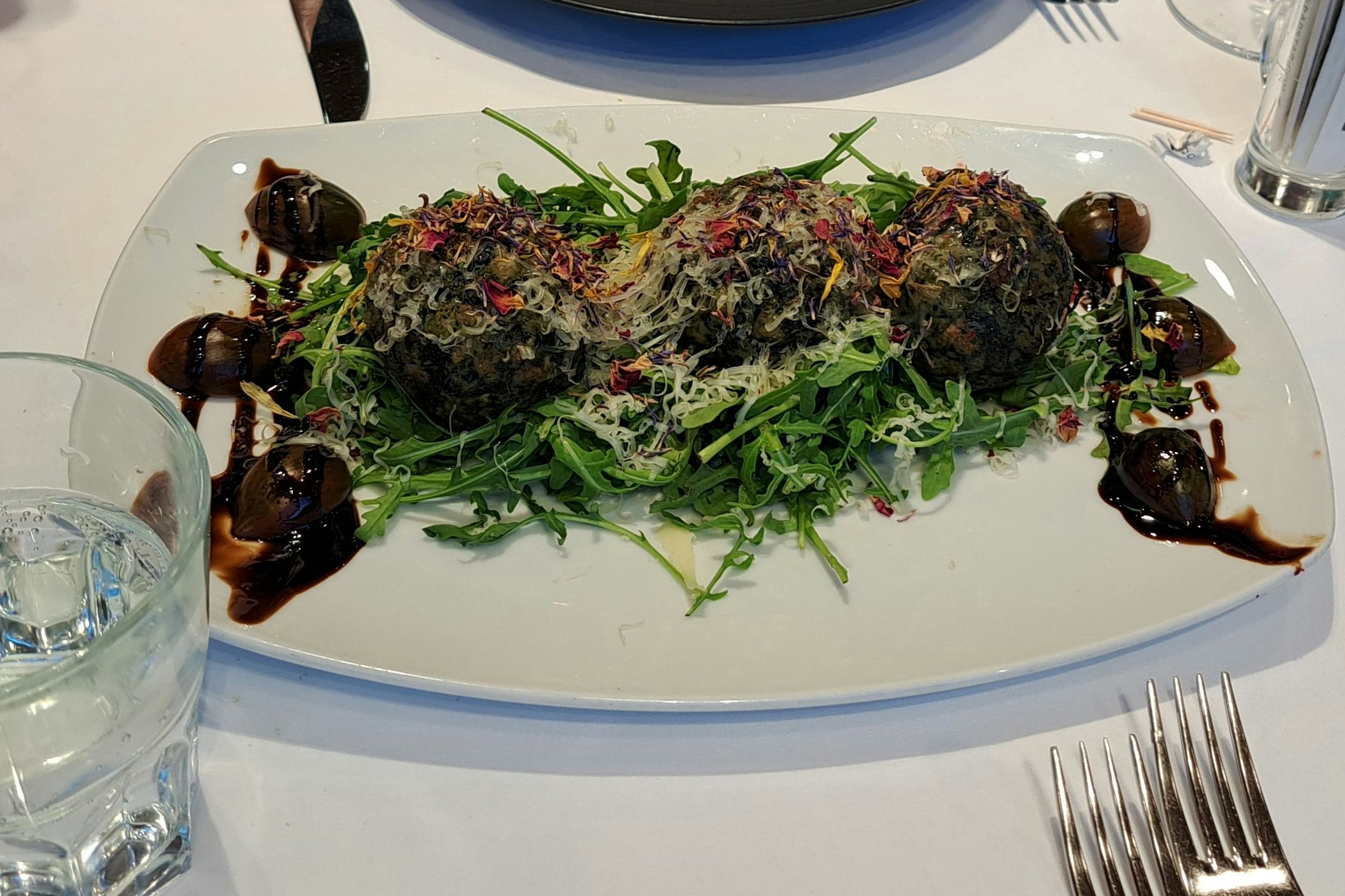Spinatknödel mit brauner Butter und Bergkäse auf Rucola
