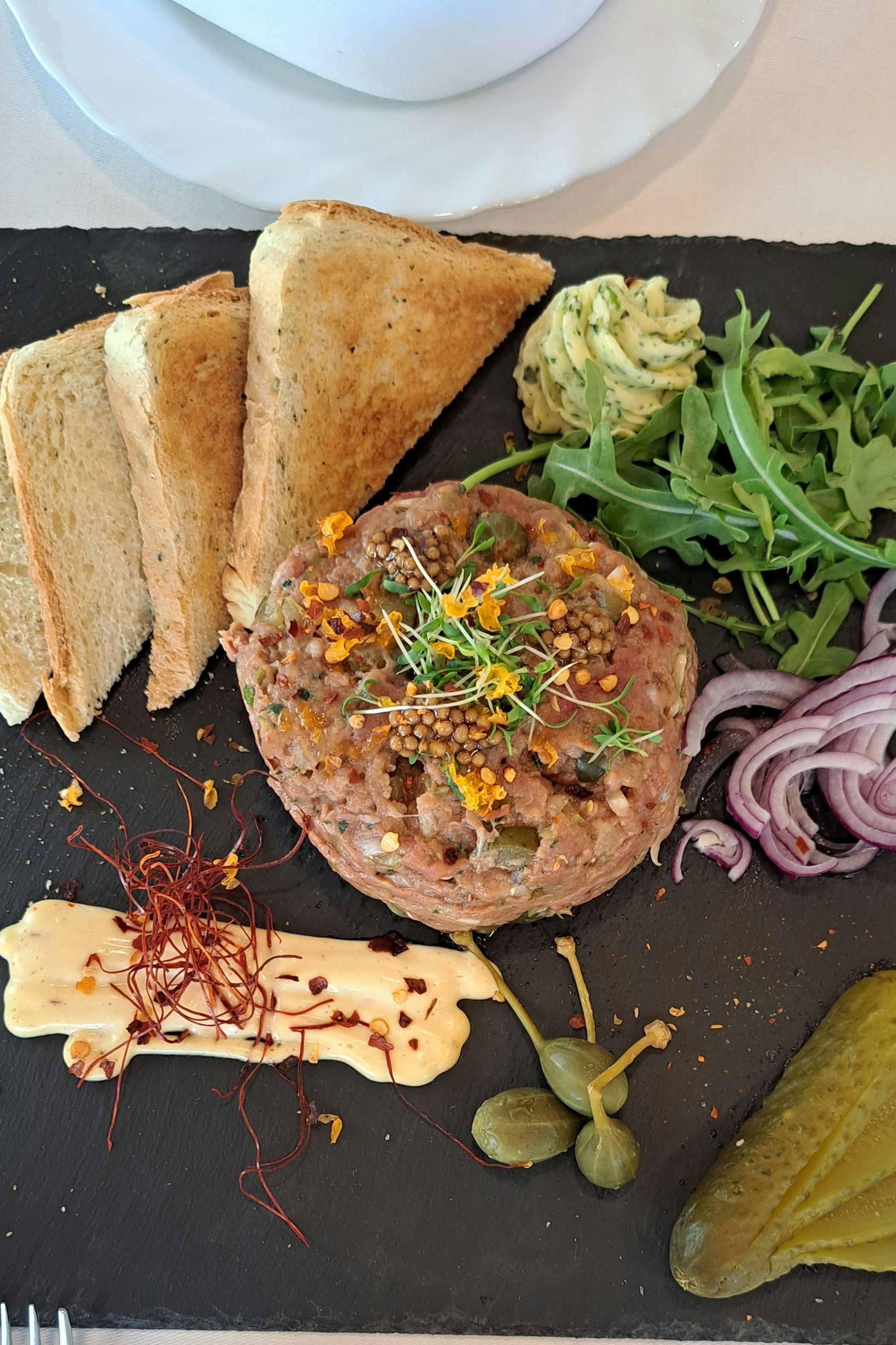 "Papp'nschmierer" bei der "Tour de Staud" am Yppenplatz: Beef Tartar vom Hödl mit gebeiztem Ei, roter Zwiebel, Kräuterbutter, Chili-Mayonnaise und natürlich Gurkerln von Staud's