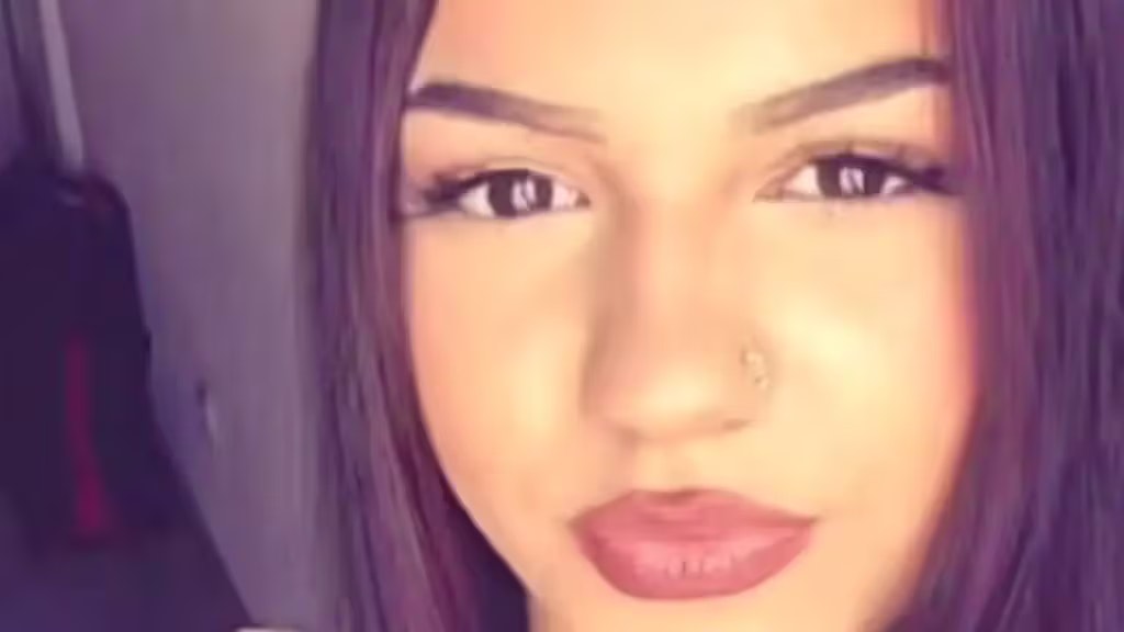 Alysha ist 163 Zentimeter gross, schlank, hat lange, dunkle Haare, eine Zahnspange, ein Nasen- und ein Zungen-Piercing sowie ein Blumen-Tattoo am rechten Unterarm.