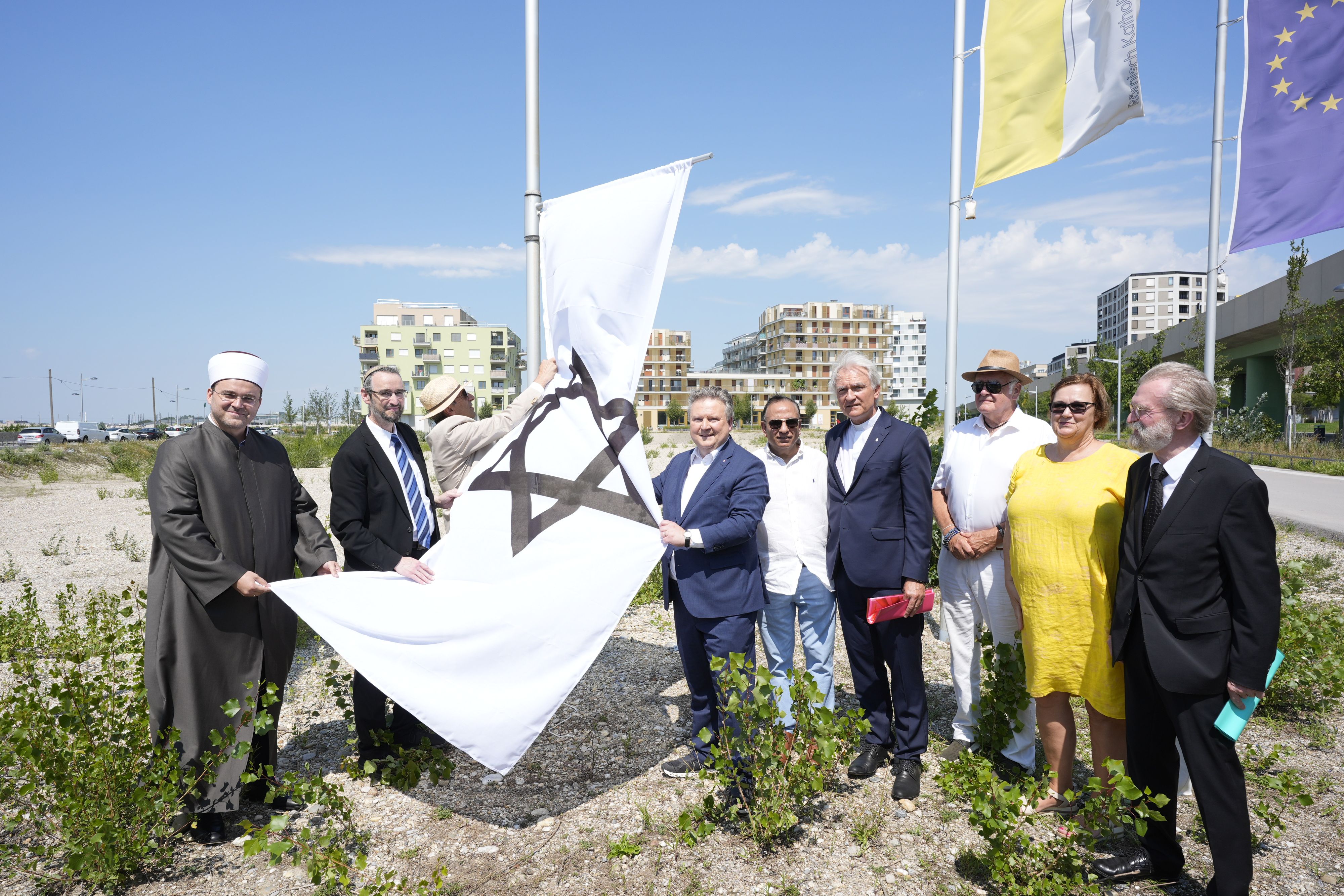 Bürgermeister Ludwig (4.v.l.) und Vertreter aller acht Religionsgemeinschaften hissten die neue Fahne.