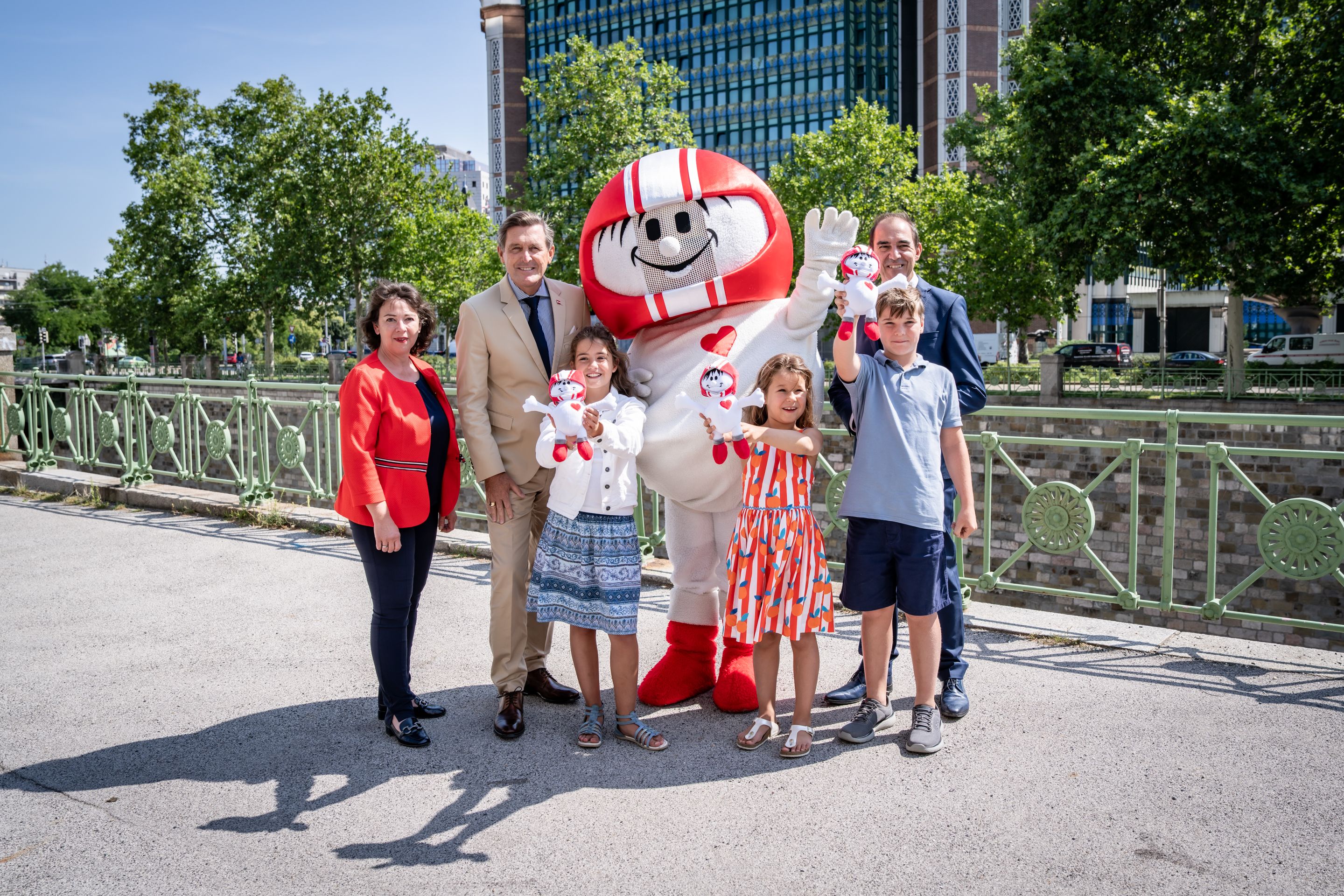 vlnr: Doris Wendler, Präsidentin des KFV (Kuratorium für Verkehrssicherheit), Mobilitätsminister Peter Hanke, Kult-Maskottchen Helmi, Christian Schimanovsky, Geschäftsführer des KFV und begeisterte Kinder freuen sich auf die Aktion.
