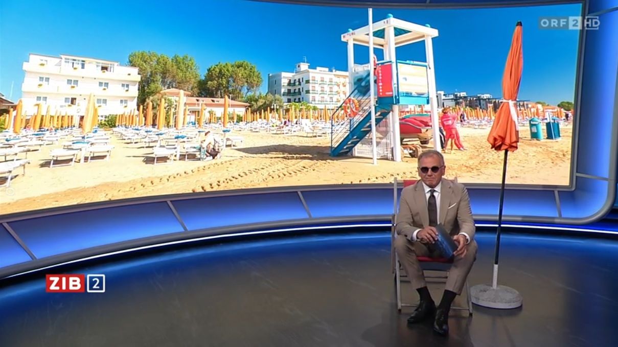 ZiB-Moderator Armin Wolf überrascht mit Sonnenbrille und Strandsessel.