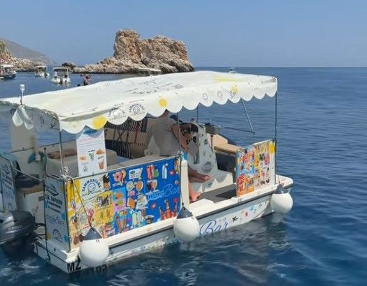 Während andere ihre Eisvitrine im Geschäft haben, schippert dieser Mann seine übers türkisfarbene Wasser.