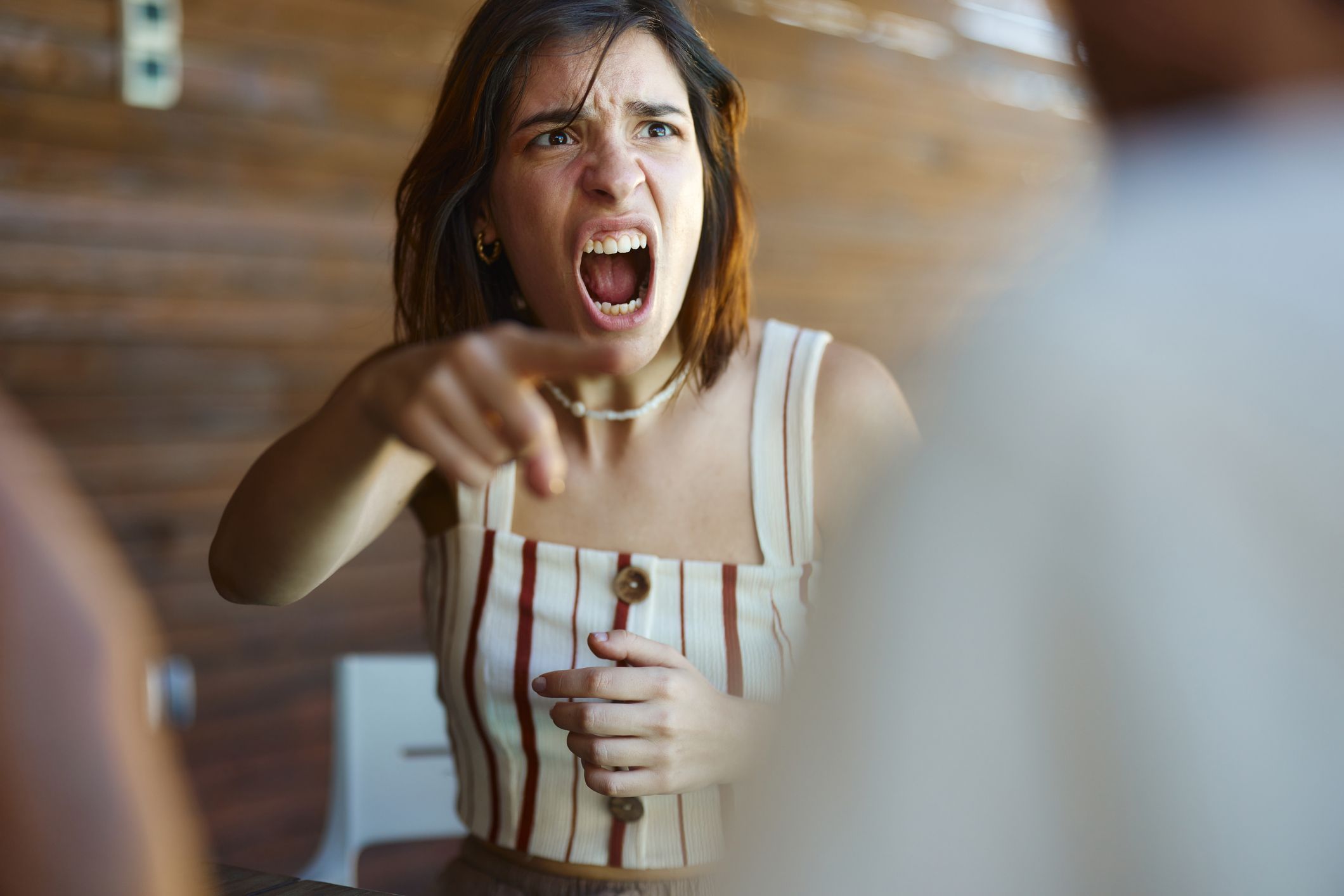Displeased woman screaming in frustration while arguing with her boyfriend.