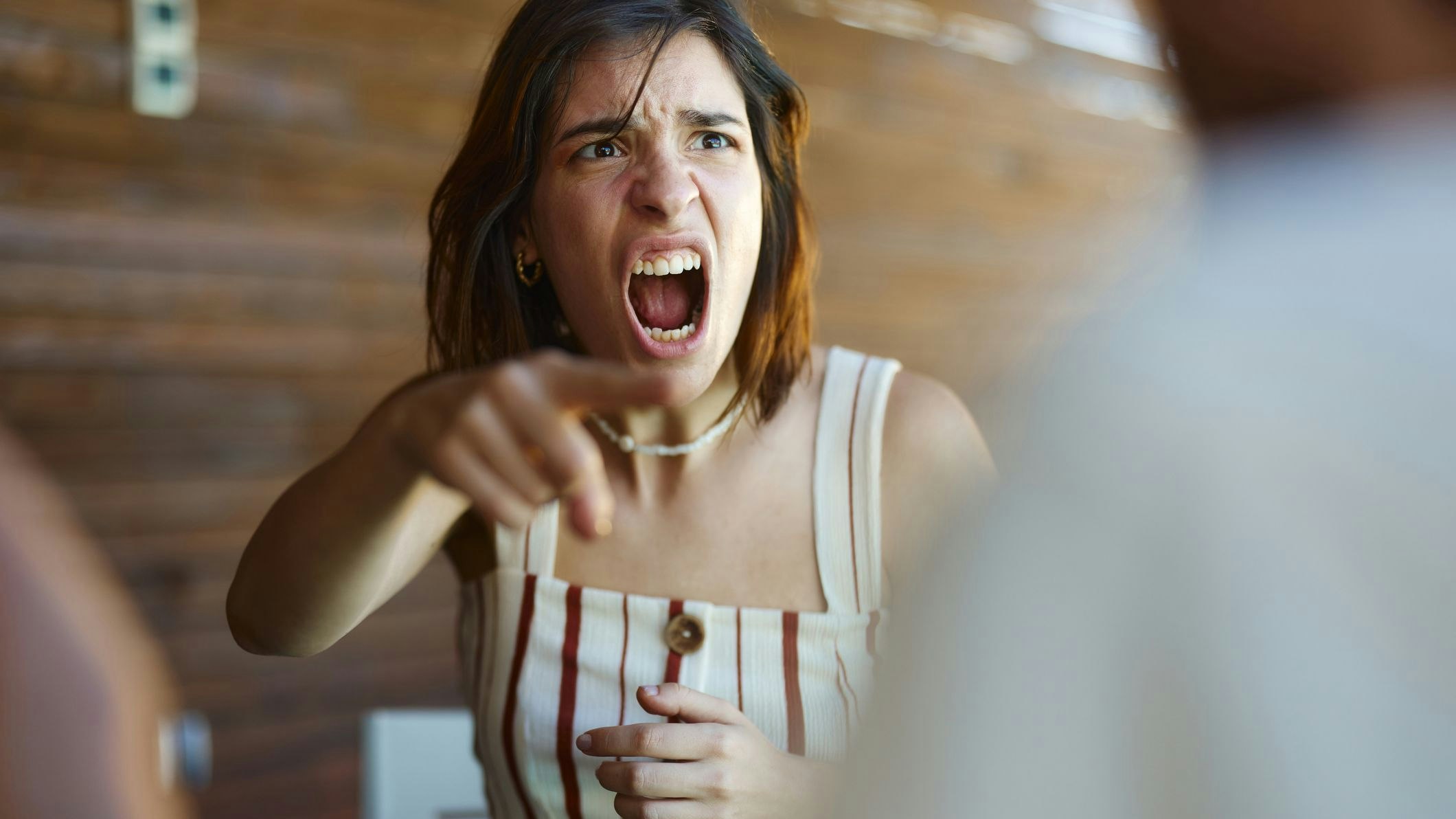 Displeased woman screaming in frustration while arguing with her boyfriend.