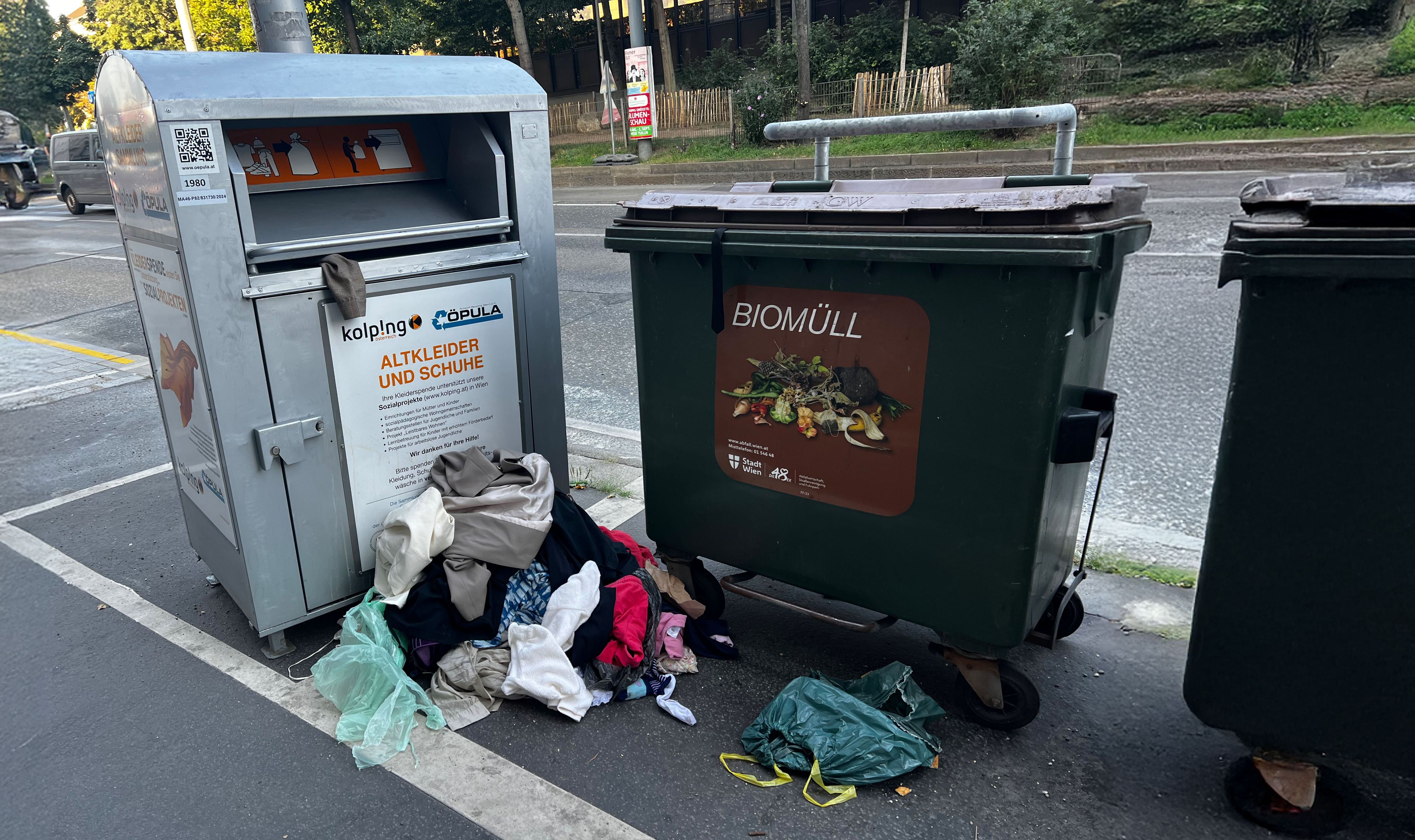 Kleiderhaufen am Gehsteig: Nach Plünderungen bleibt der Inhalt eines Altkleidercontainers achtlos neben der Tonne liegen.