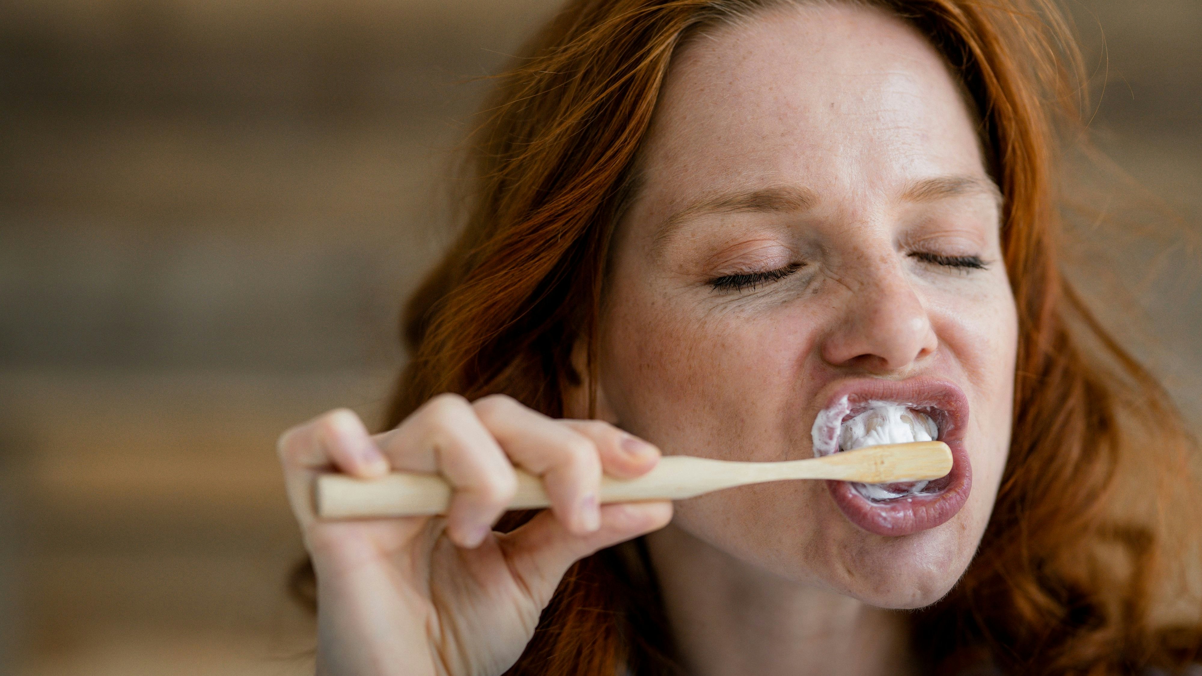  Portrait of redheaded woman brushing teeth model released Symbolfoto property released PUBLICATIONxINxGERxSUIxAUTxHUNxONLY KNSF06520