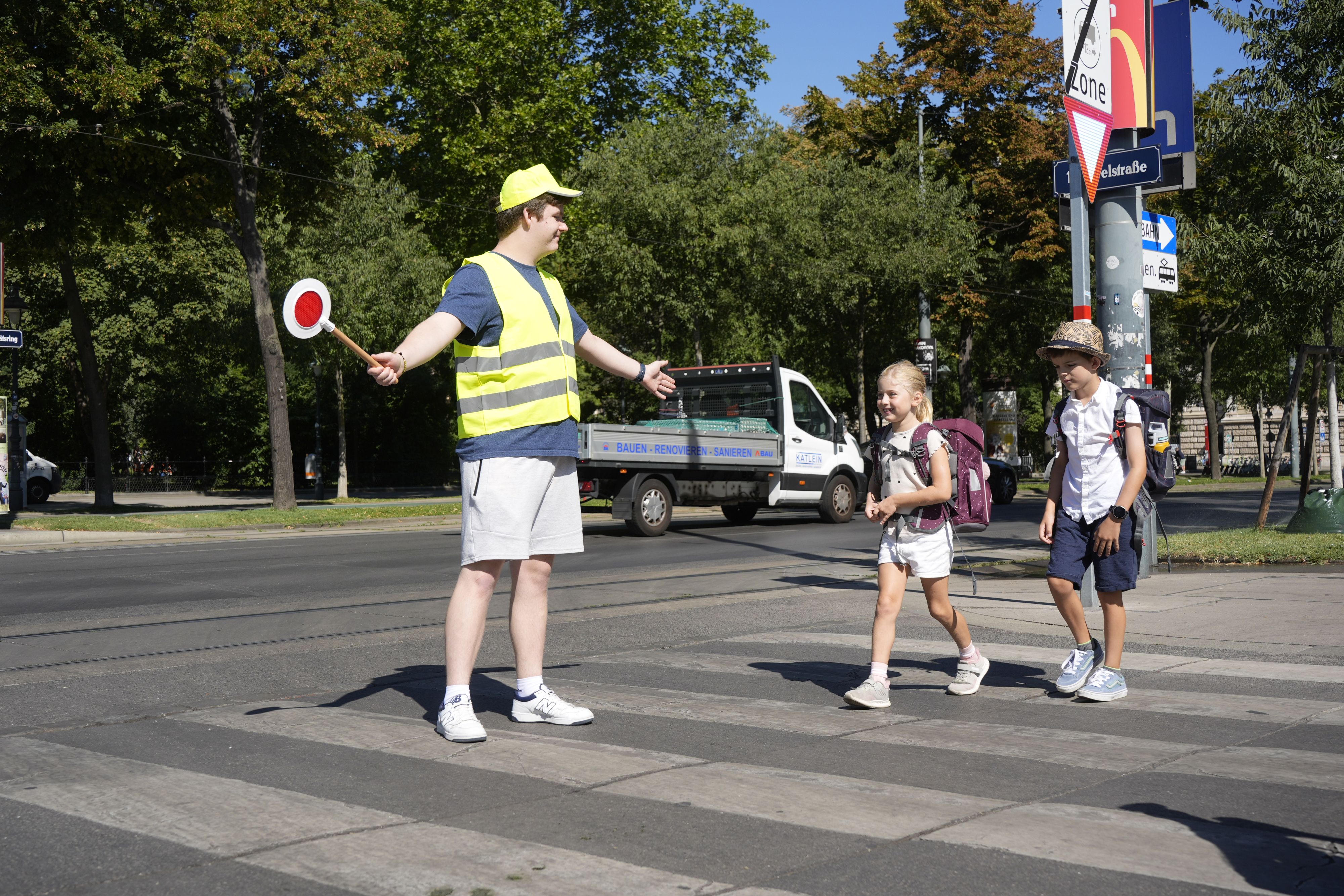 Schülerlotse Sebastian sichert den Schulweg von Emma (6) und Florian (8).