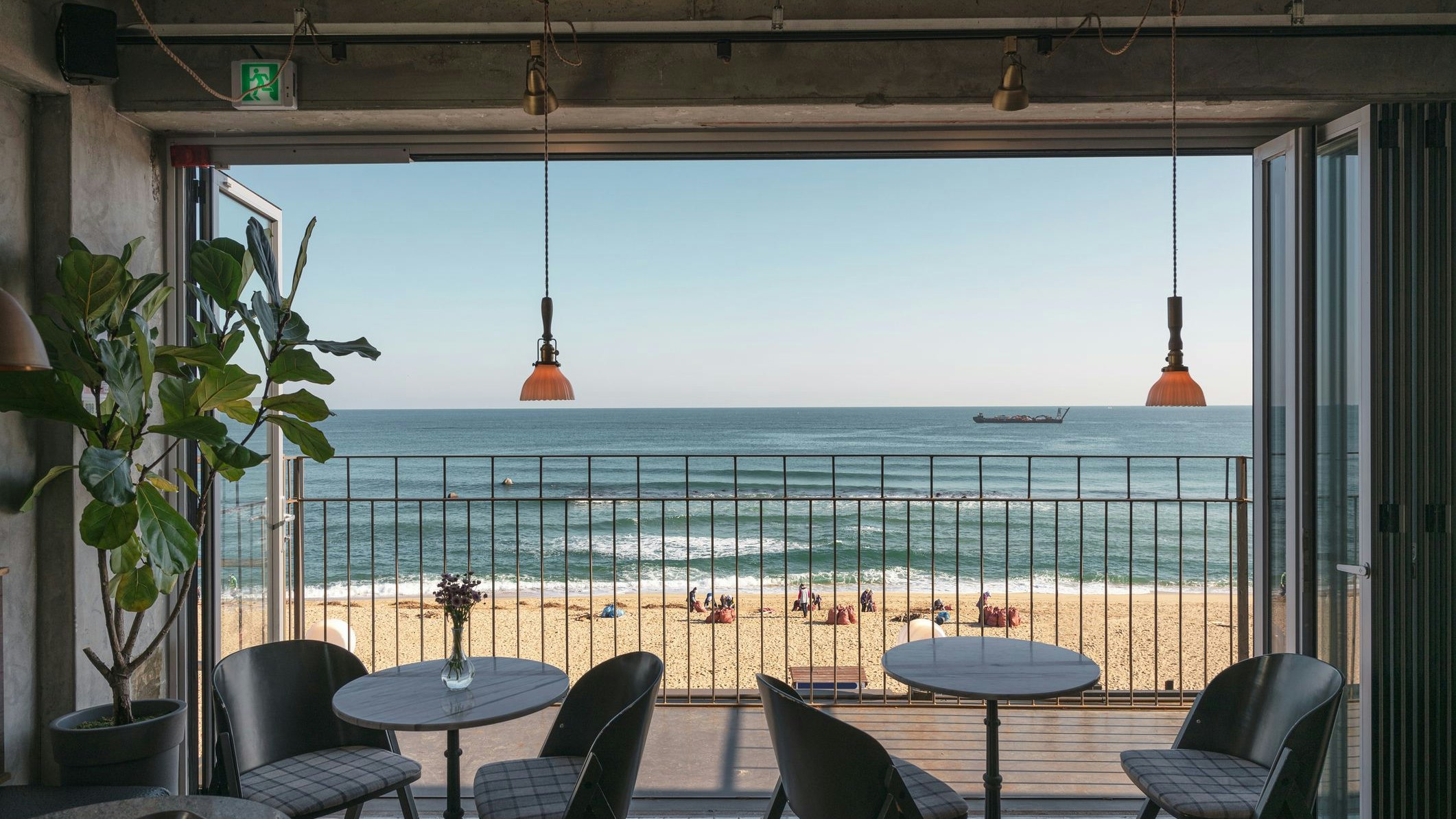 Table and chairs with wooden patio on the beach in tropical sea