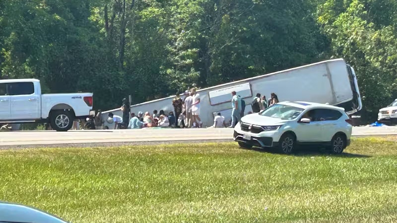 Berichten zufolge sind 52 Personen betroffen, die teils aus dem Bus geschleudert wurden, teils darin eingeklemmt sind.