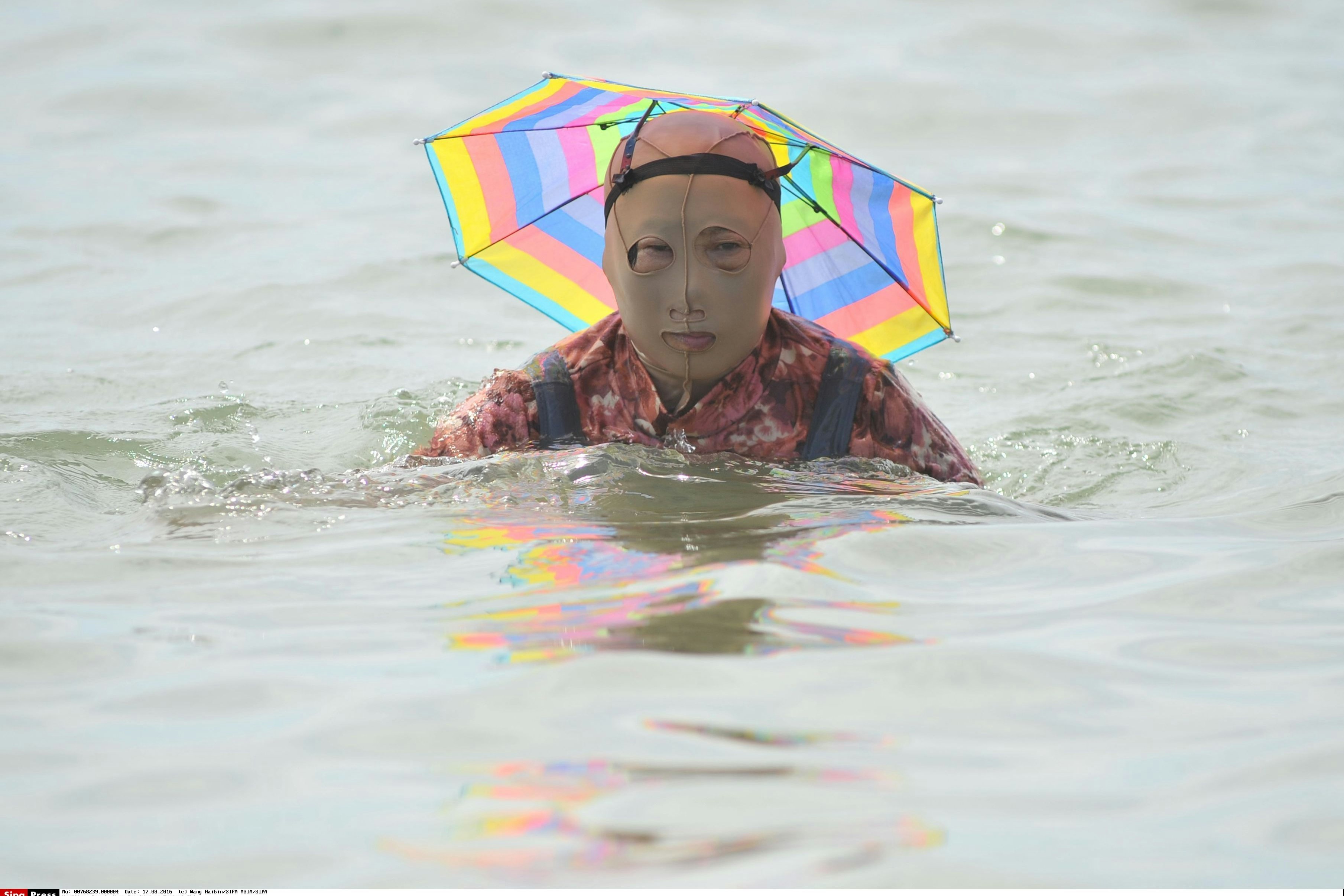Doppelt hält besser: Zum Facekini kommt hier noch ein kleiner Sonnenschirm auf den Kopf