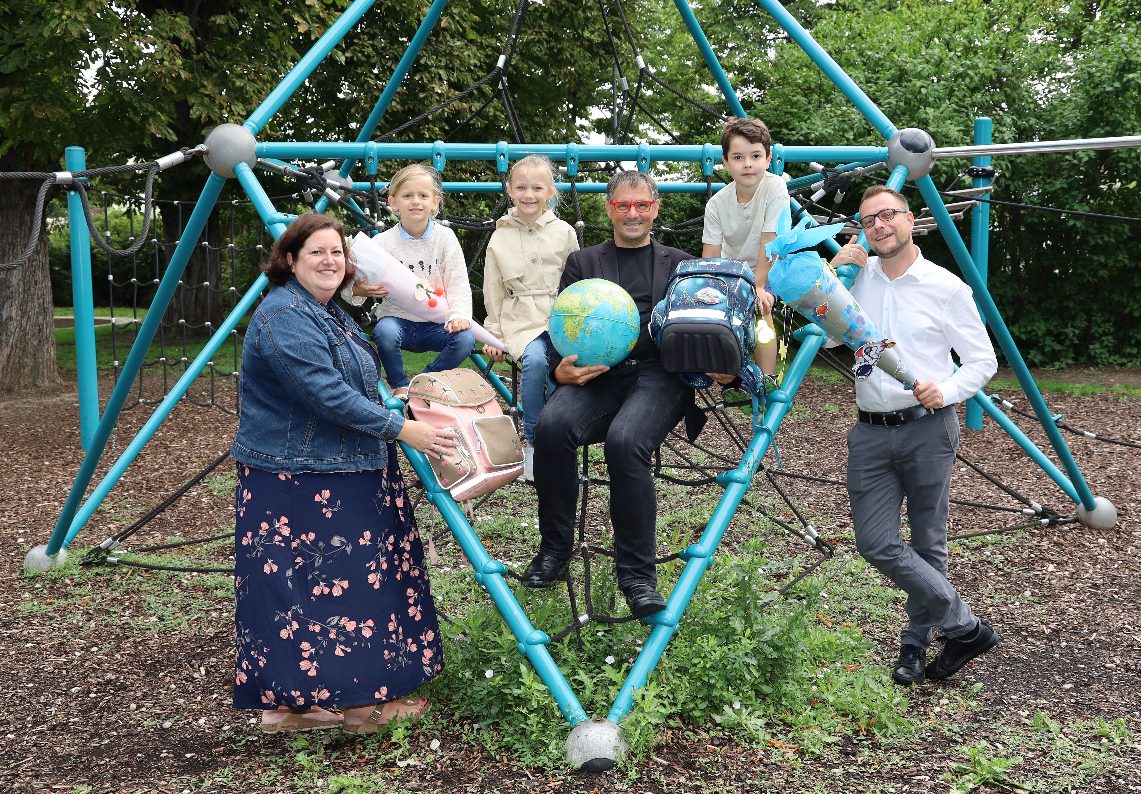 Bürgermeisterin Sabrina Divoky, Schulstadtrat Norbert Ciperle und Vizebürgermeister Clemens Zinnbauer freuen sich gemeinsam mit Cleo, Romy und David auf den Schulstart