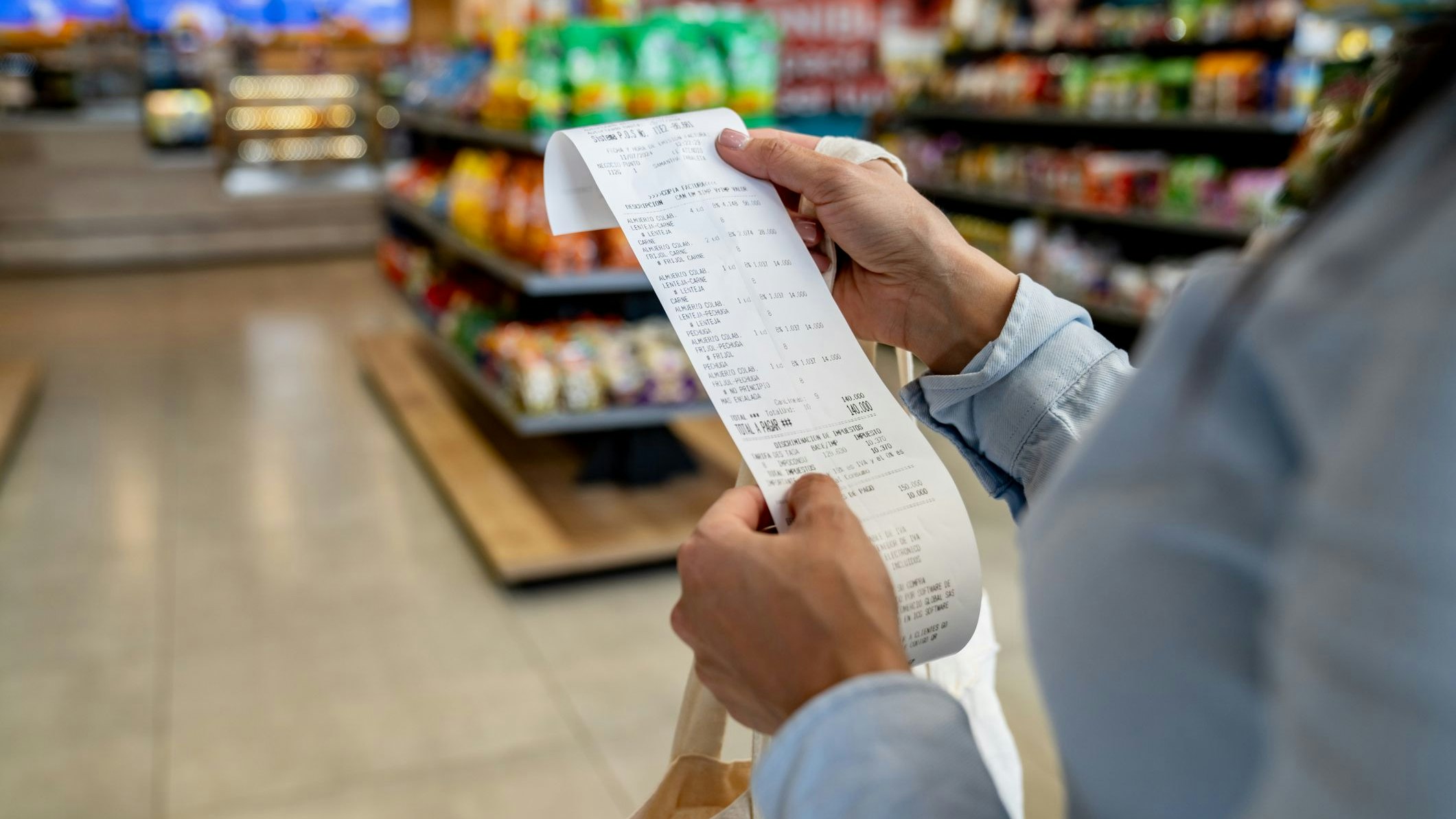 Close-up on a woman shopping at a convenience store and checking her receipt while exiting