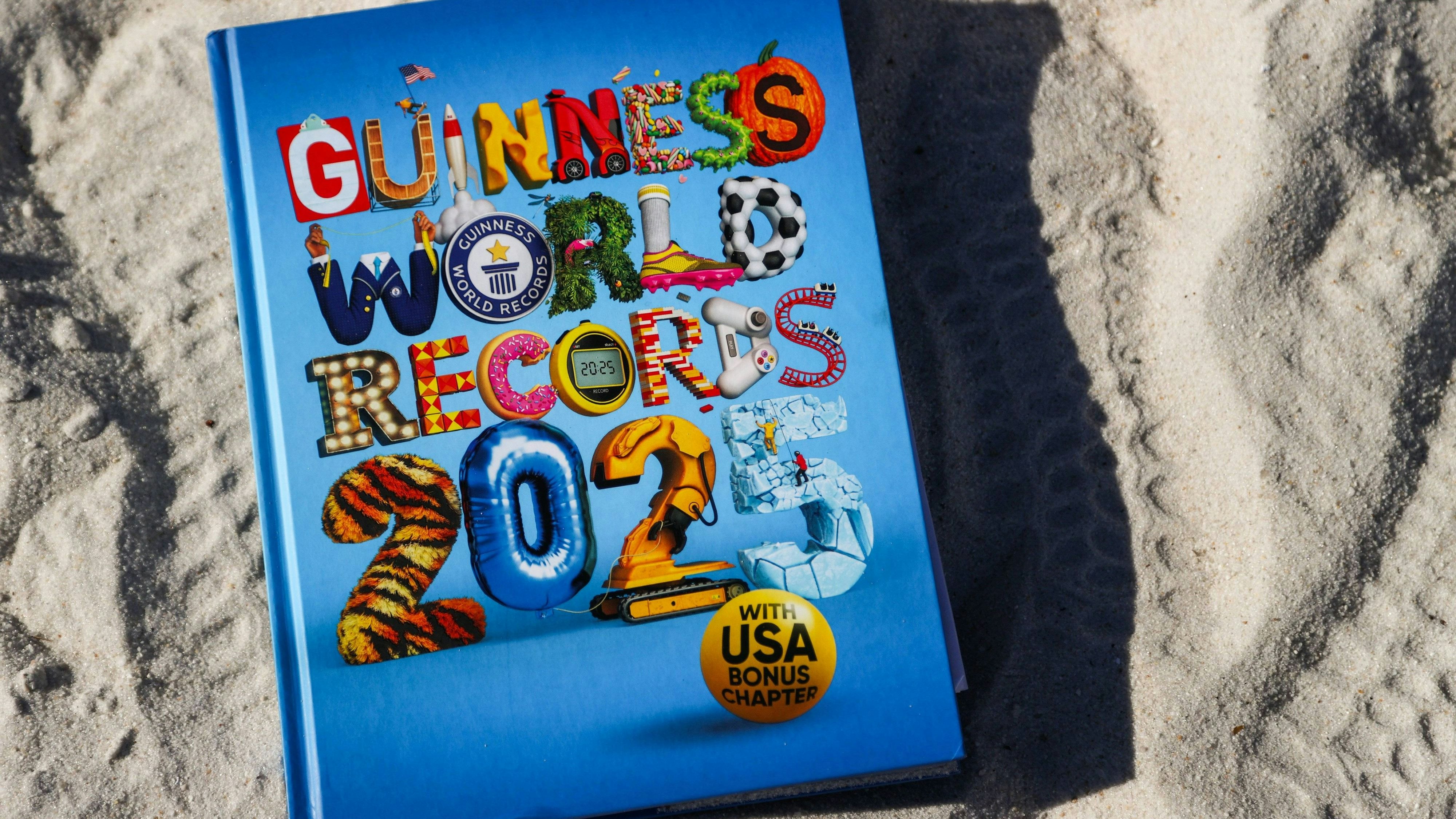 December 3, 2024, St. Petersburg, Florida, USA: The Guinness Book of World Records 2025 in the sand on the beach at Eckerd College s south beach on Tuesday, Dec. 3, 2024, in St. Petersburg. Aidan Webster, 21, a senior at Eckerd, majoring in oceanography, holds three records in the 2025 Guinness Book and has just broken a fifth one for juggling five knives at a time. His other records include: longest time juggling three flaming torches, most back somersaults in one minute, most juggling catches in 1 minute with one hand while hanging from the other. St. Petersburg USA - ZUMAs70_ 20241203_zan_s70_018 Copyright: xDirkxShaddx