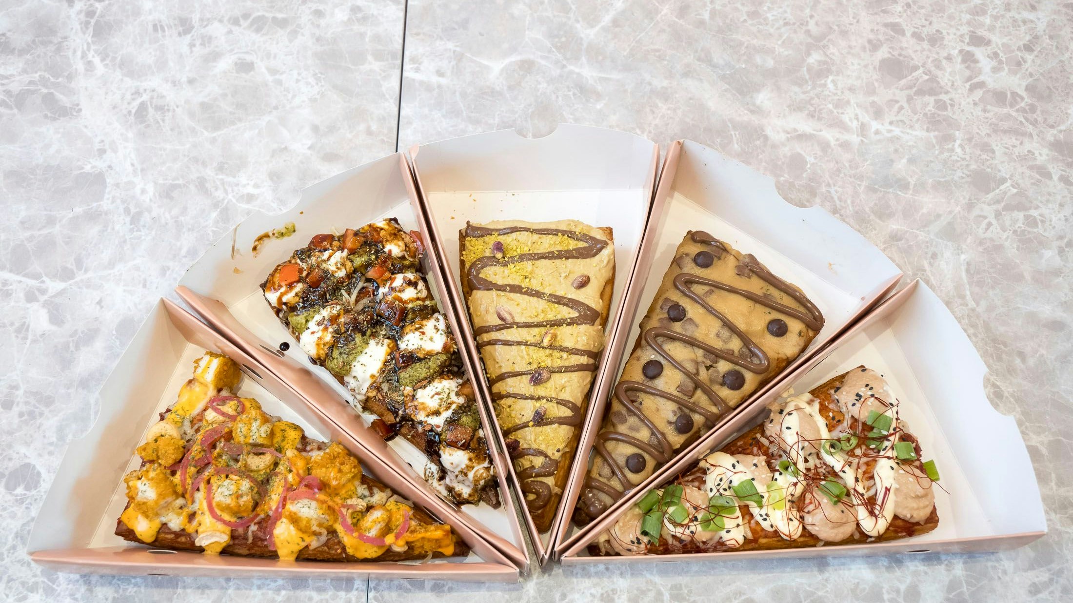 Die Slices (v.l.): Hot Cashew Chicken, Buffalla Mediterrana, Dubai Special, The Cookie-Croissant, May-Wasabi Tonno.