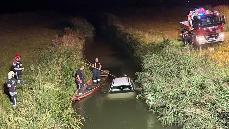 Das weiße Auto landete vom Feldweg im Bach.