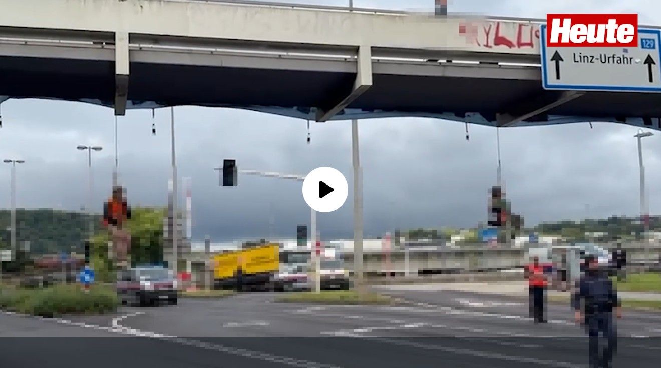 Am Video ist zu sehen, wie zwei Aktivisten an einem Seil von der Fußgängerbrücke hängen. 