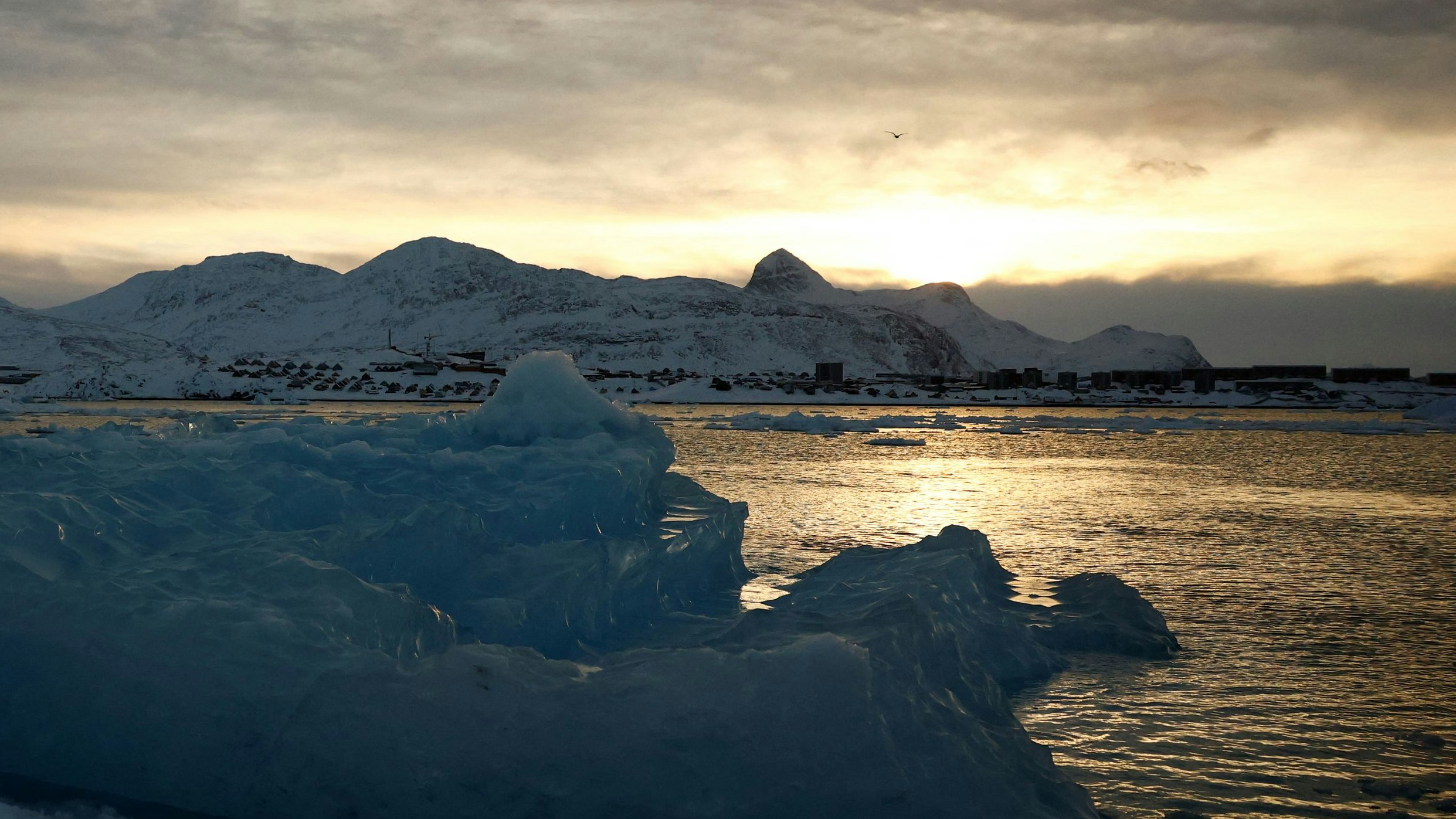 An iceberg floats in front of the city of Nuuk as the sun rises, Greenland, February 9, 2025. REUTERS/Sarah Meyssonnier